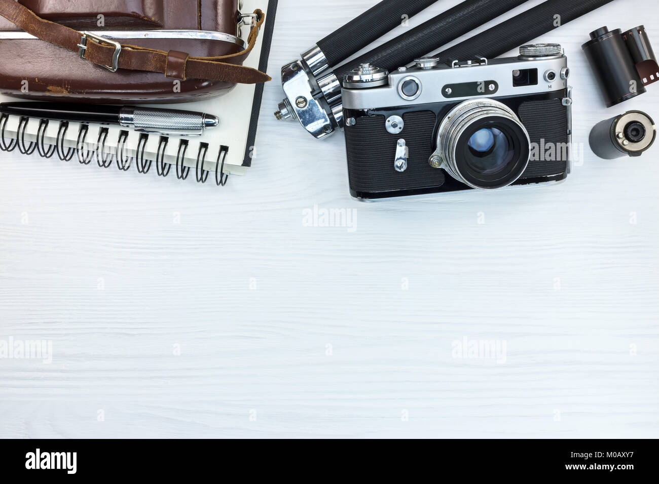 Altes Foto Kamera mit Ledertasche, Stativ, Bleistift und Notizbuch auf weißem Holz- Hintergrund mit Kopie Raum Stockfoto