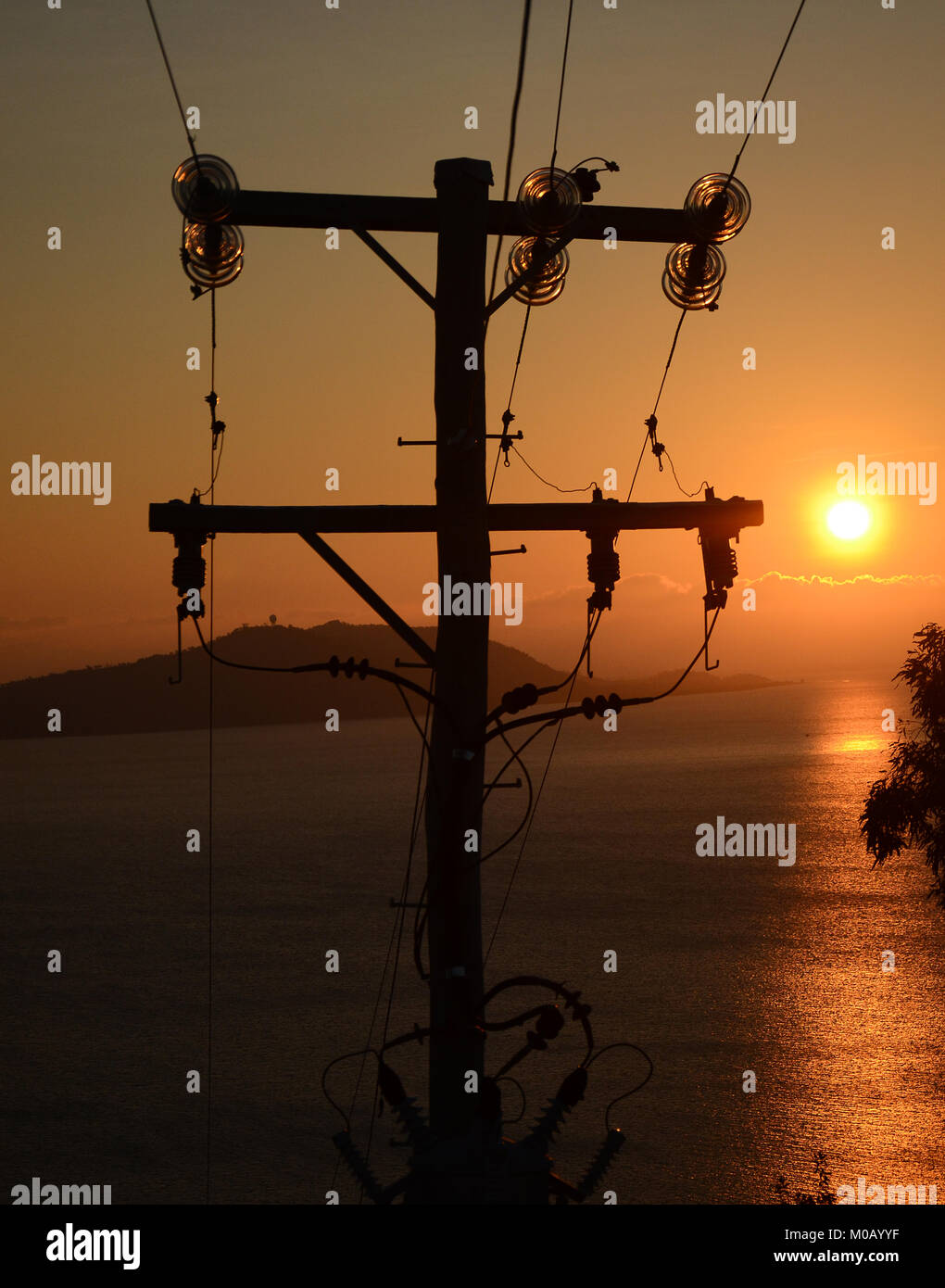 Telefonmast in Silhouette am schönen Sonnenuntergang, faseroptische Kommunikation Stockfoto