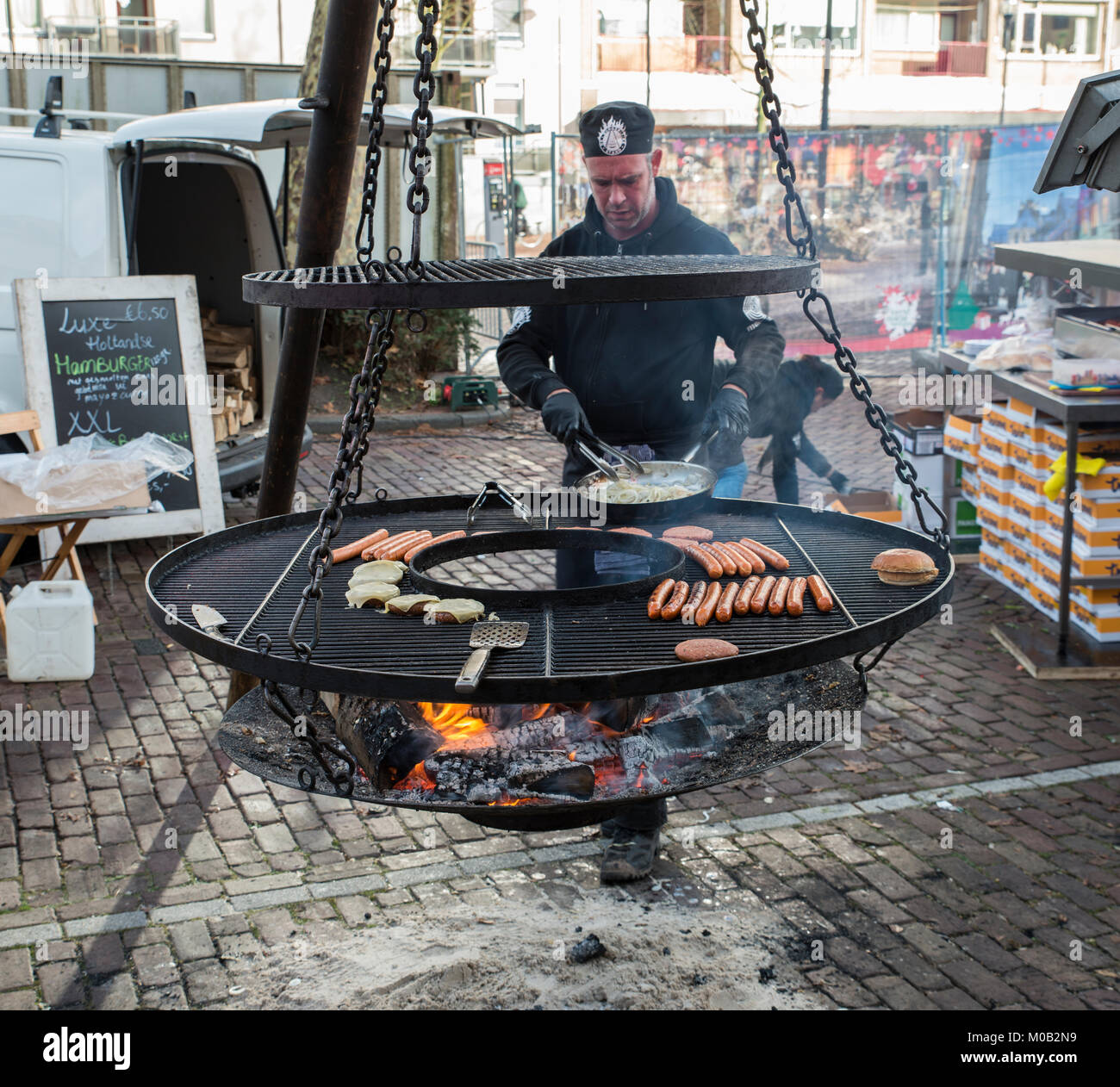 Mann, Speisen auf dem Grill, beim Weihnachtsmarkt in Dordrecht Holland Stockfoto