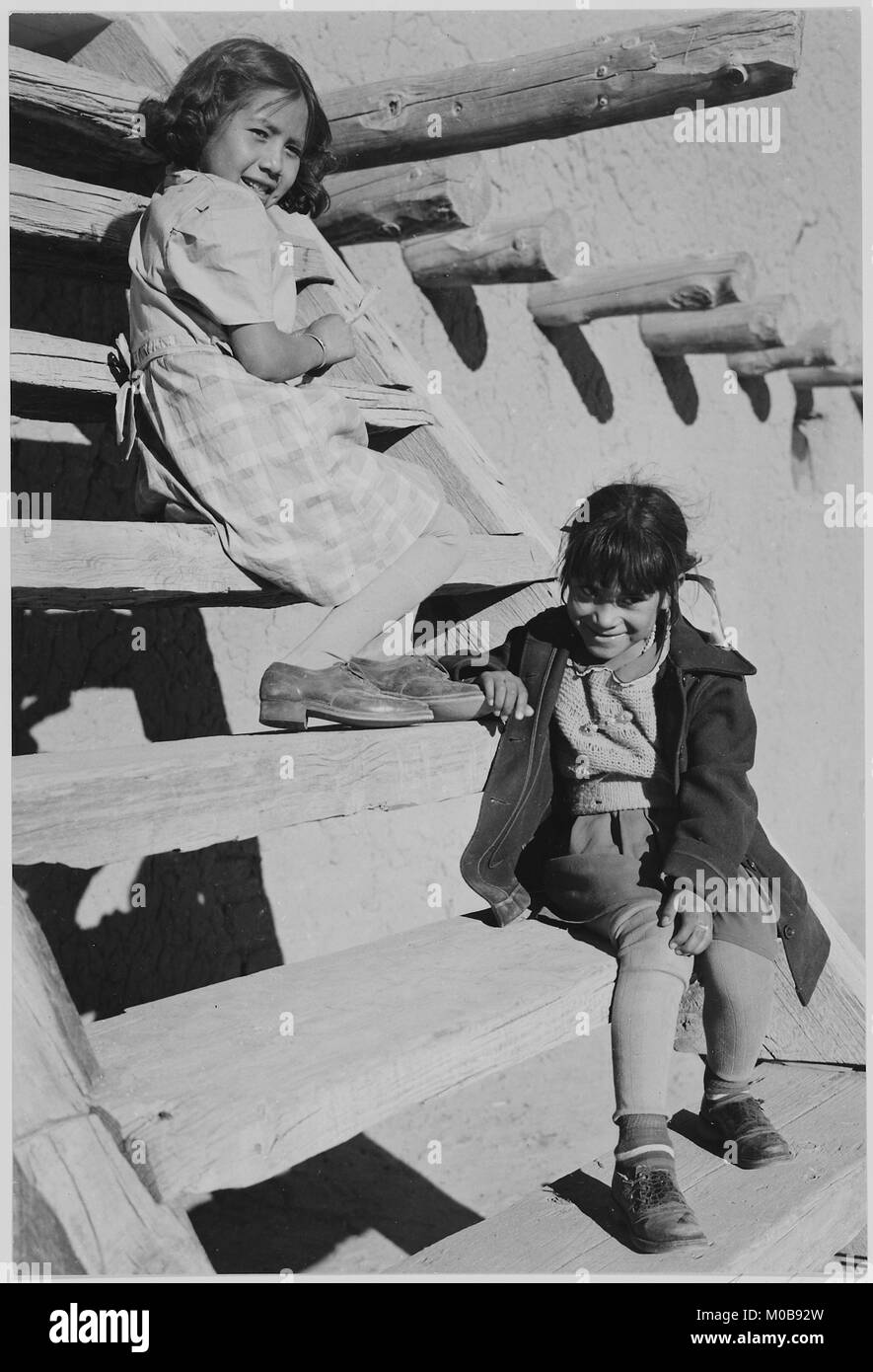 Zwei junge Mädchen sitzen auf Schritte. Bei San Ildefonso Pueblo New Mexico 1942.' (vertikale Ausrichtung) 1942 Stockfoto
