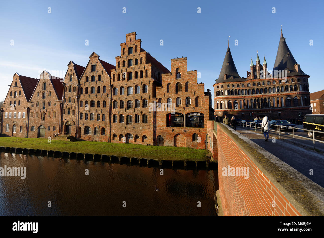 Lübeck, Deutschland - 30. Dezember 2016: Menschen bei Salz Lagerhäusern und Holstentor. Aufgrund seiner umfangreichen Backsteingotik, die Stadt ist Liste Stockfoto