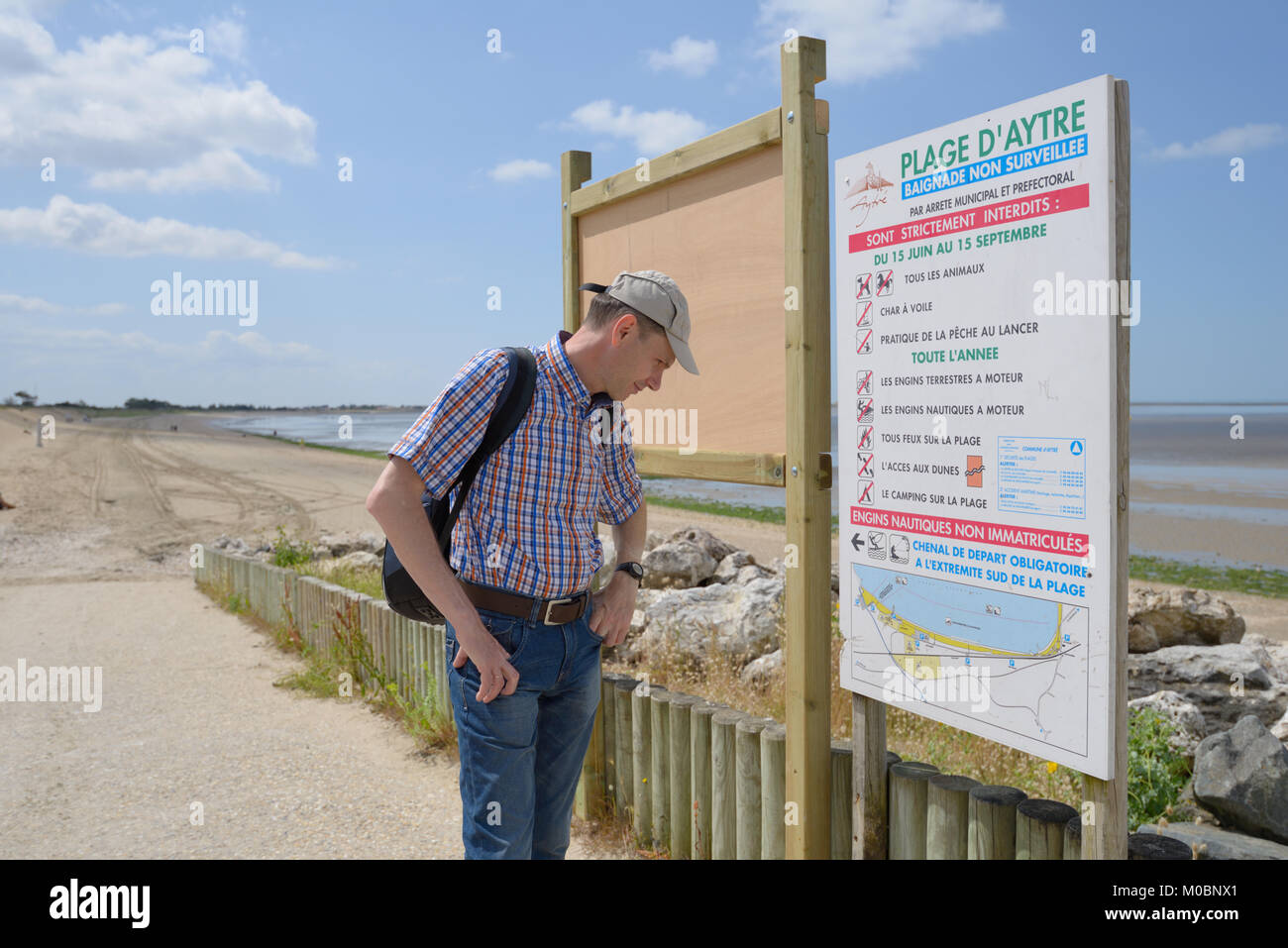 Aytre, Poitou-Charentes, Frankreich - 25. Juni 2013: Touristische Lesen der Regeln am Strand. Der Strand ist flach und seicht, was es zu einer guten Badeplatz Stockfoto