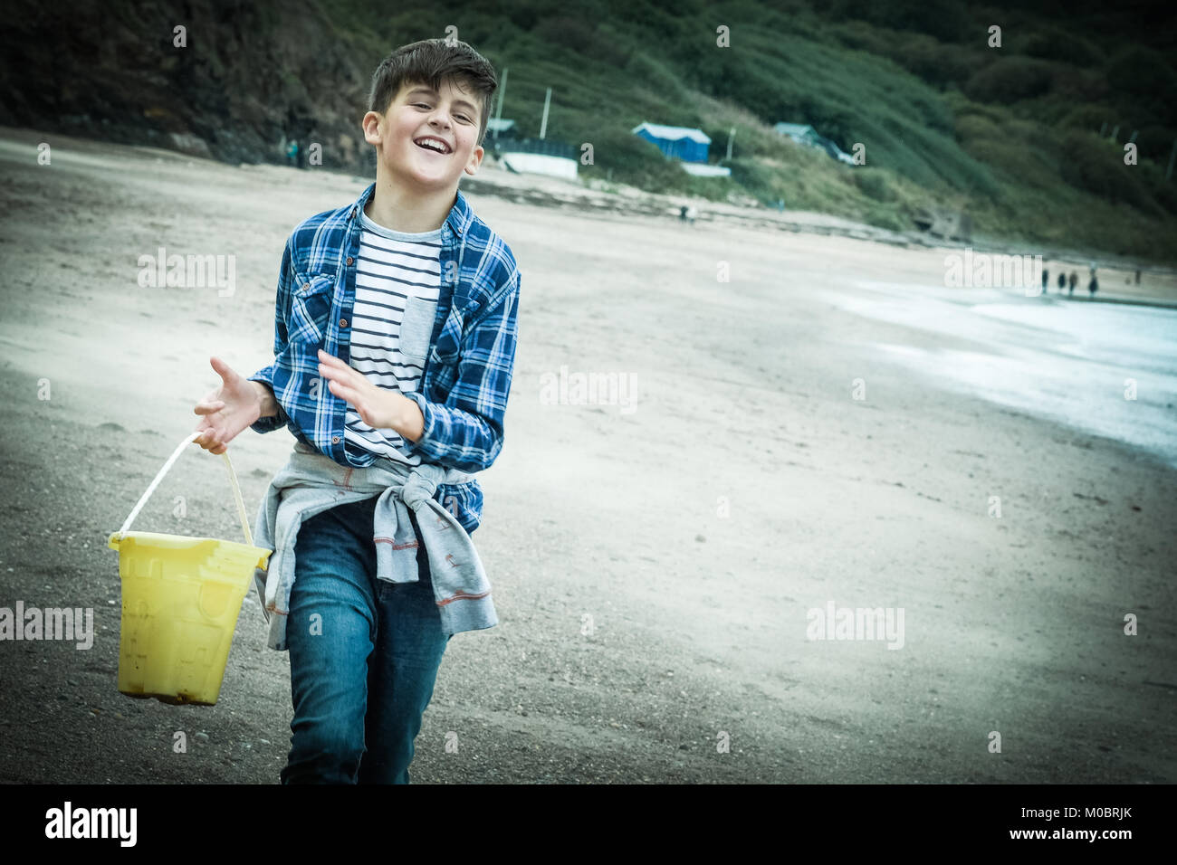 10 Jahre alte dunkelhaarige Junge genießen Urlaub Zeit, Laufen am Strand, [Songbook] Bay, Yorkshire, Großbritannien. Stockfoto