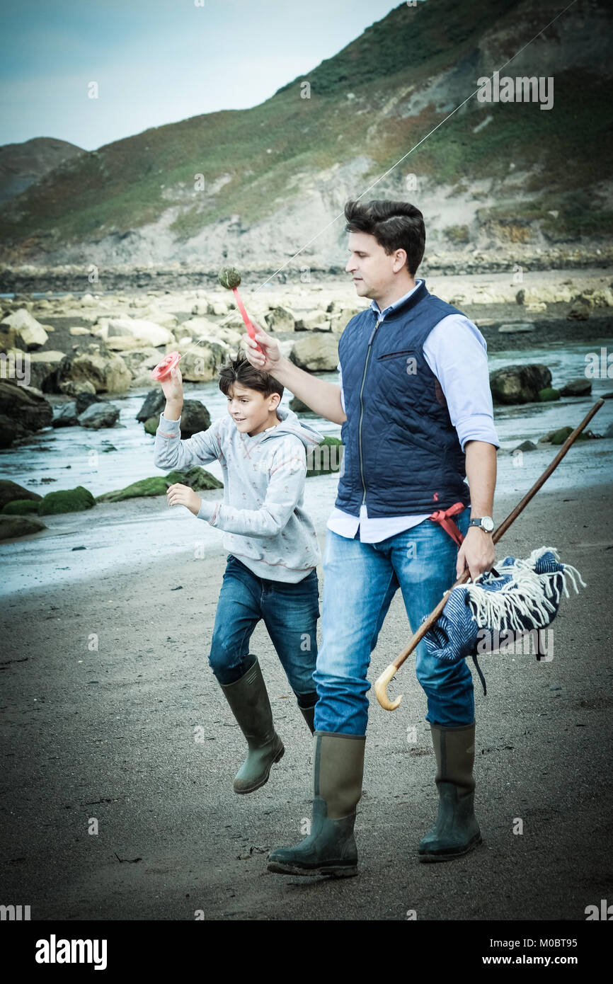 Vater und Sohn am Strand mit Drachen in [Songbook] Bay, Yorkshire, Großbritannien Stockfoto
