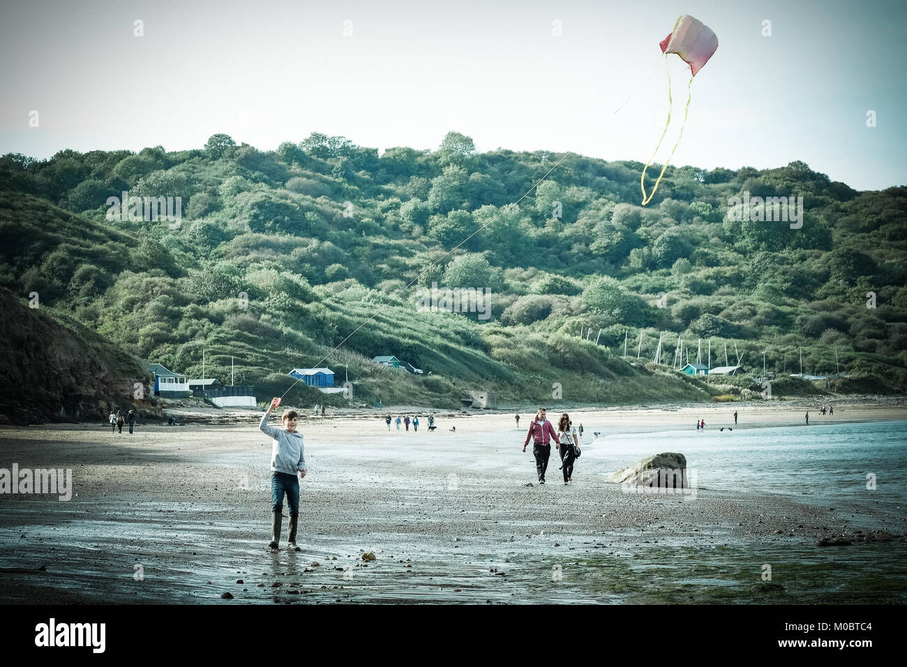10 Jahre alter Junge flying a Kite durch das Meer bei [Songbook] Bay, Yorkshire, Großbritannien Stockfoto