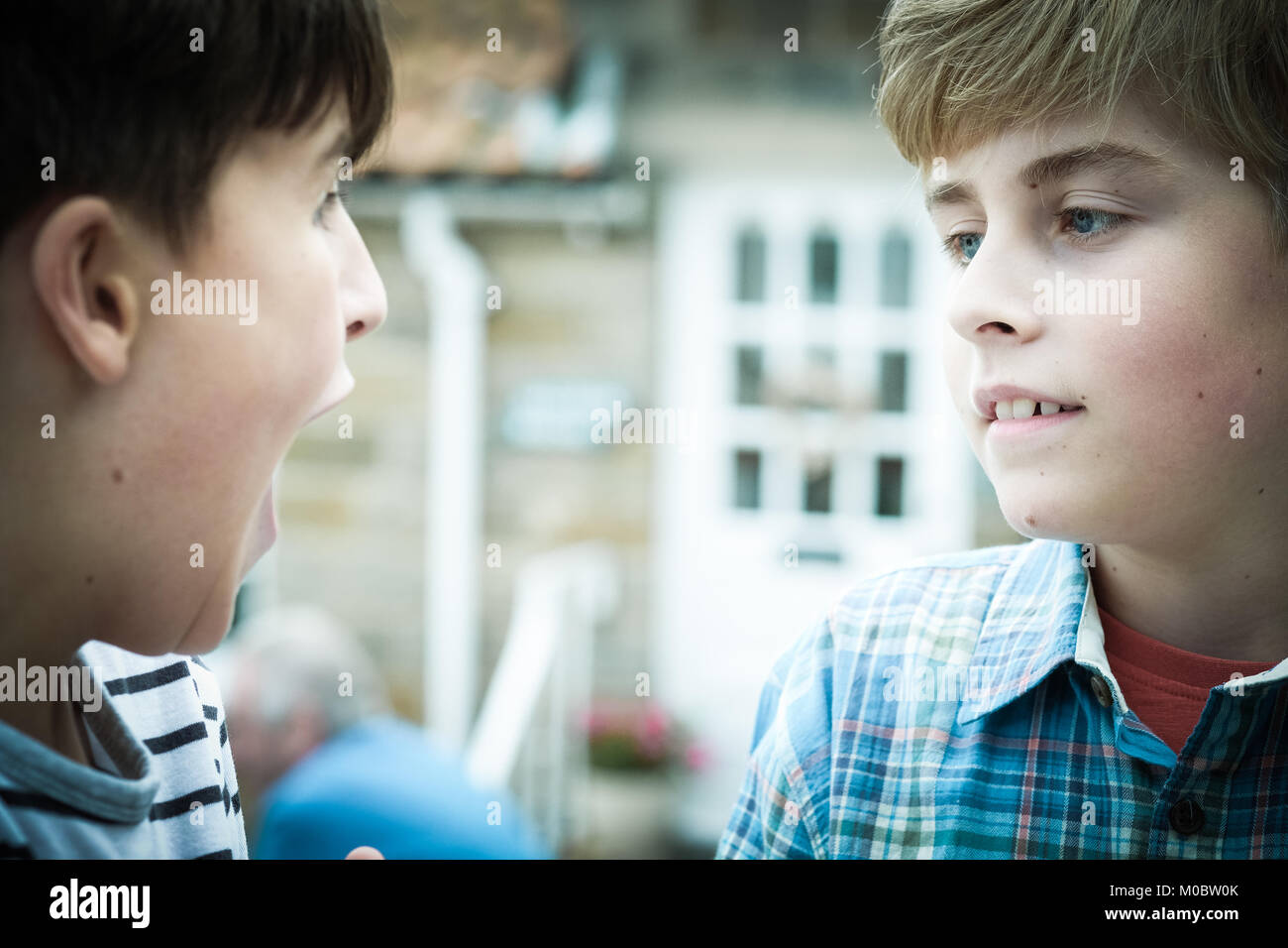 Zwei Brüder, Jungen 12 und 10 Jahre, sprechen, verspielt, den Mund offen, Nähe, Geschwister Beziehung, in [Songbook] Bay, Yorkshire, Großbritannien Stockfoto