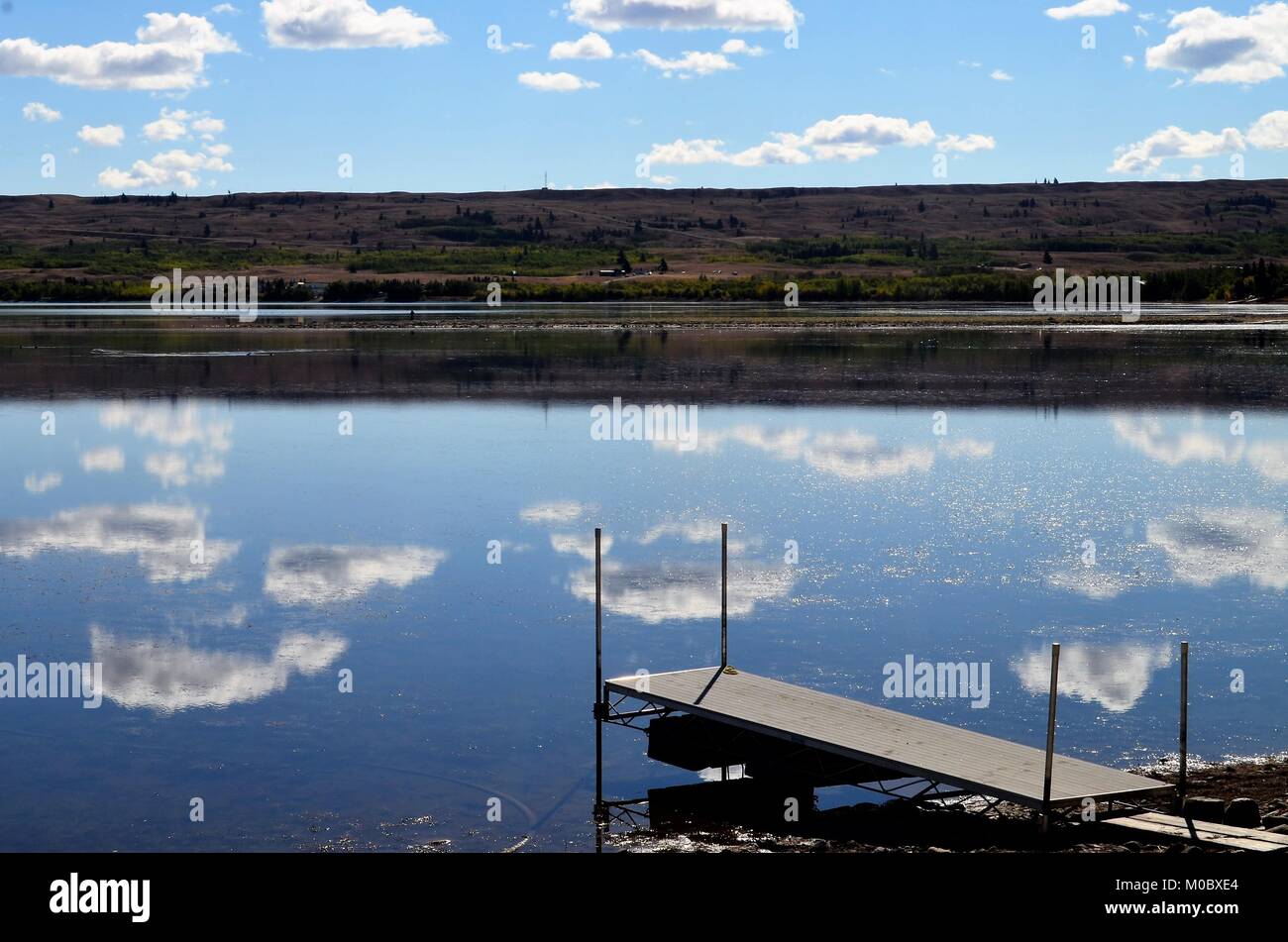 Ein wunderbares Wasser Reflexion, weiße geschwollene Wolken reflektiert von ruhigen Gewässern, an einem See in Montana, USA während der Sommermonate Stockfoto