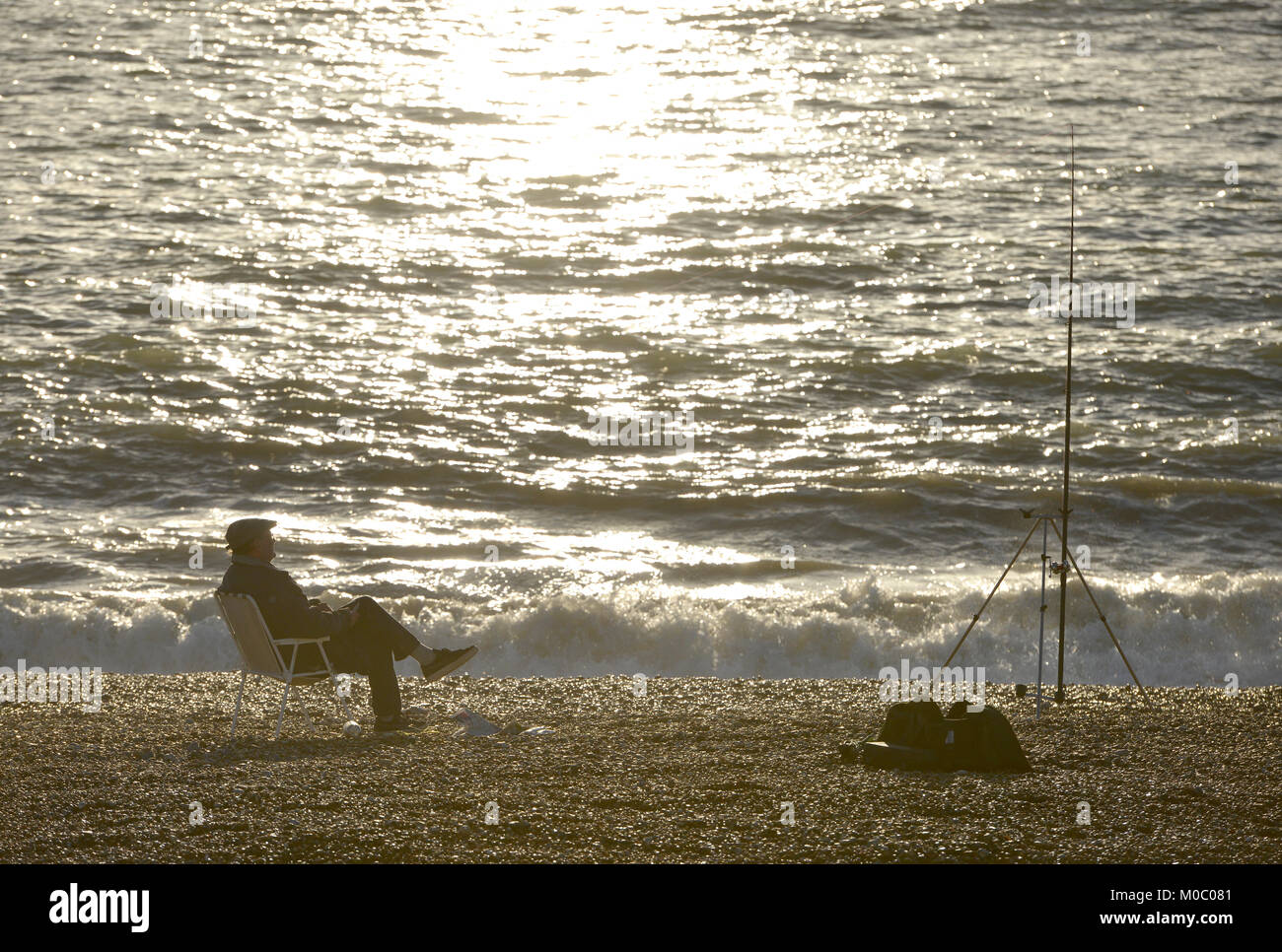 Alter Mann entspannt auf einen Stuhl, während Seefischerei in Seaford, East Sussex. Stockfoto