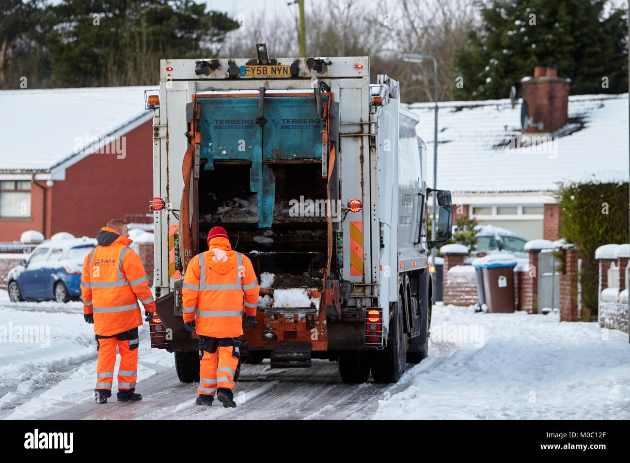 Arbeitnehmer mit Abfall Recycling Sammlung Lkw entlang der Straße im Schnee in Newtownabbey Nordirland fahren Stockfoto