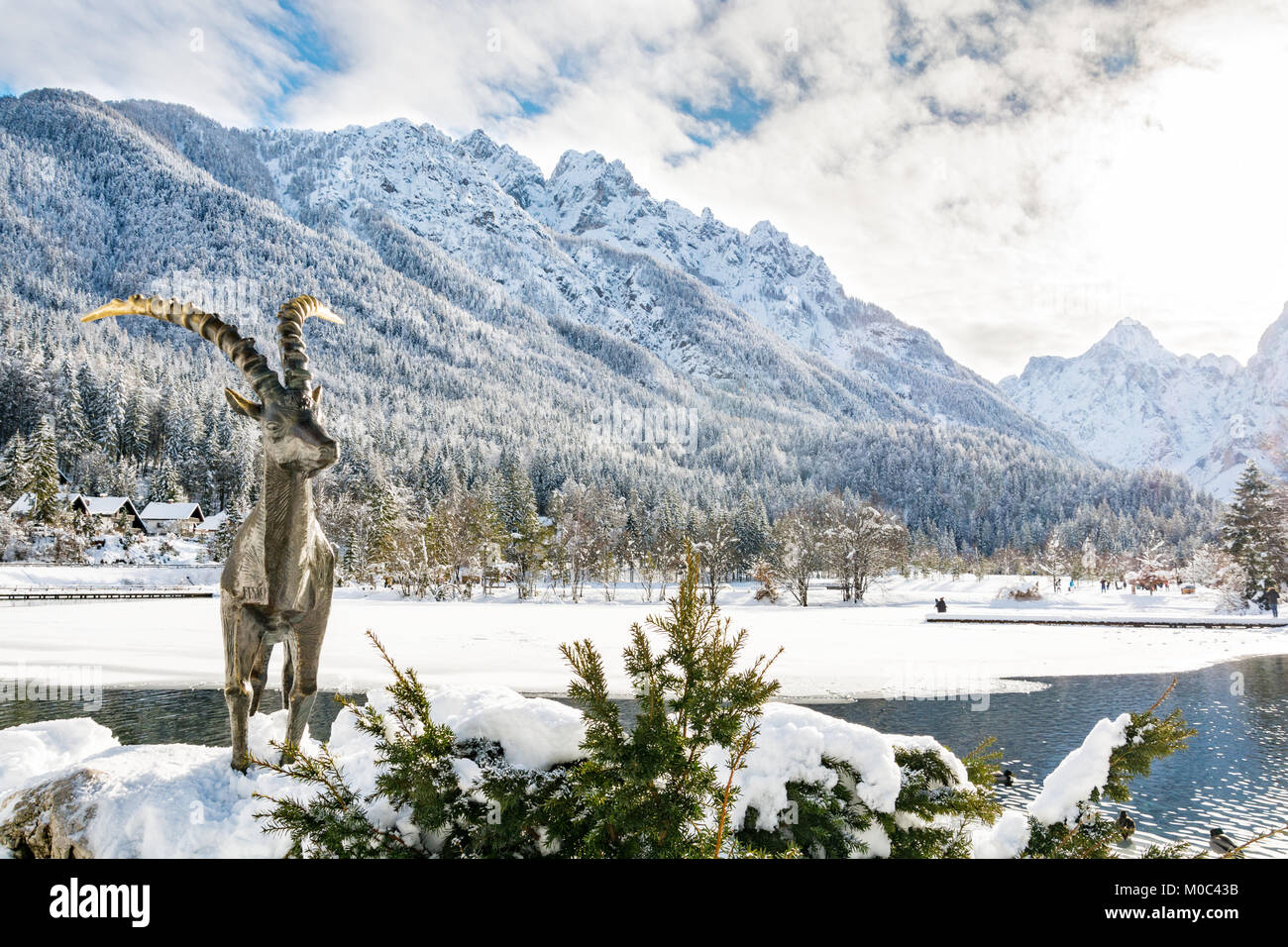 Sonnigen Tag am See Jasna in Kranjska Gora durch die Statue eines Gold gehörnten Steinbock bewacht Stockfoto