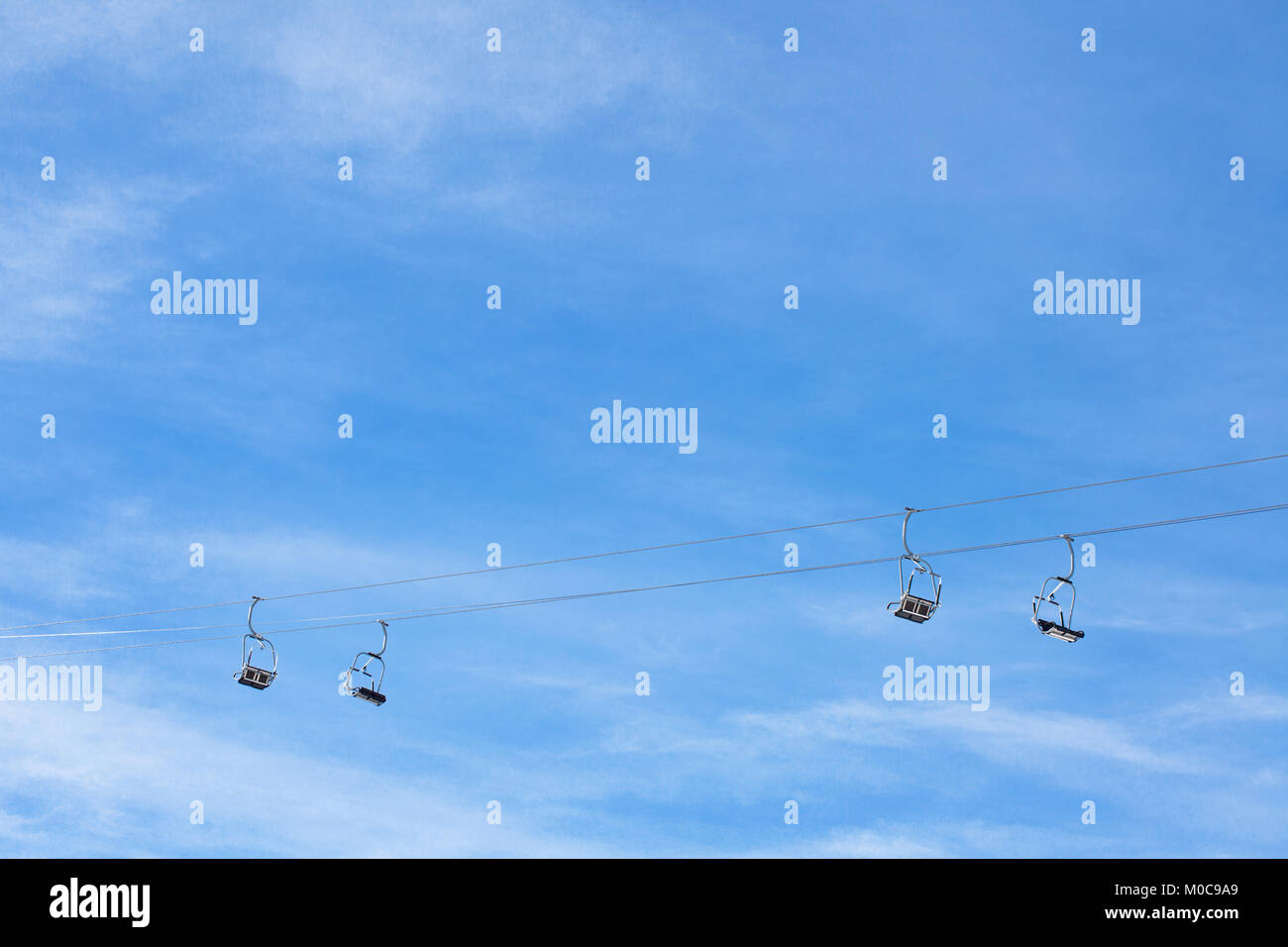 Ski Sessellift mit zwei Kabeln und vier Doppel sitze, gegen den blauen Himmel Stockfoto