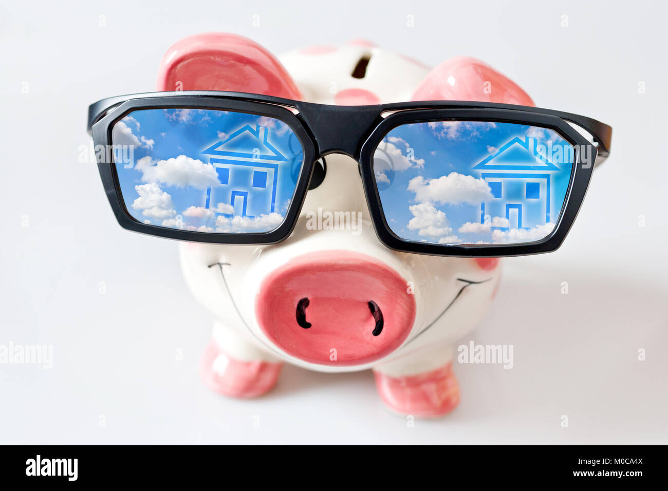Wirtschaft und Finanzen - Sparschwein mit Brille und geträumt - Einsparungen für ein neues Haus Stockfoto
