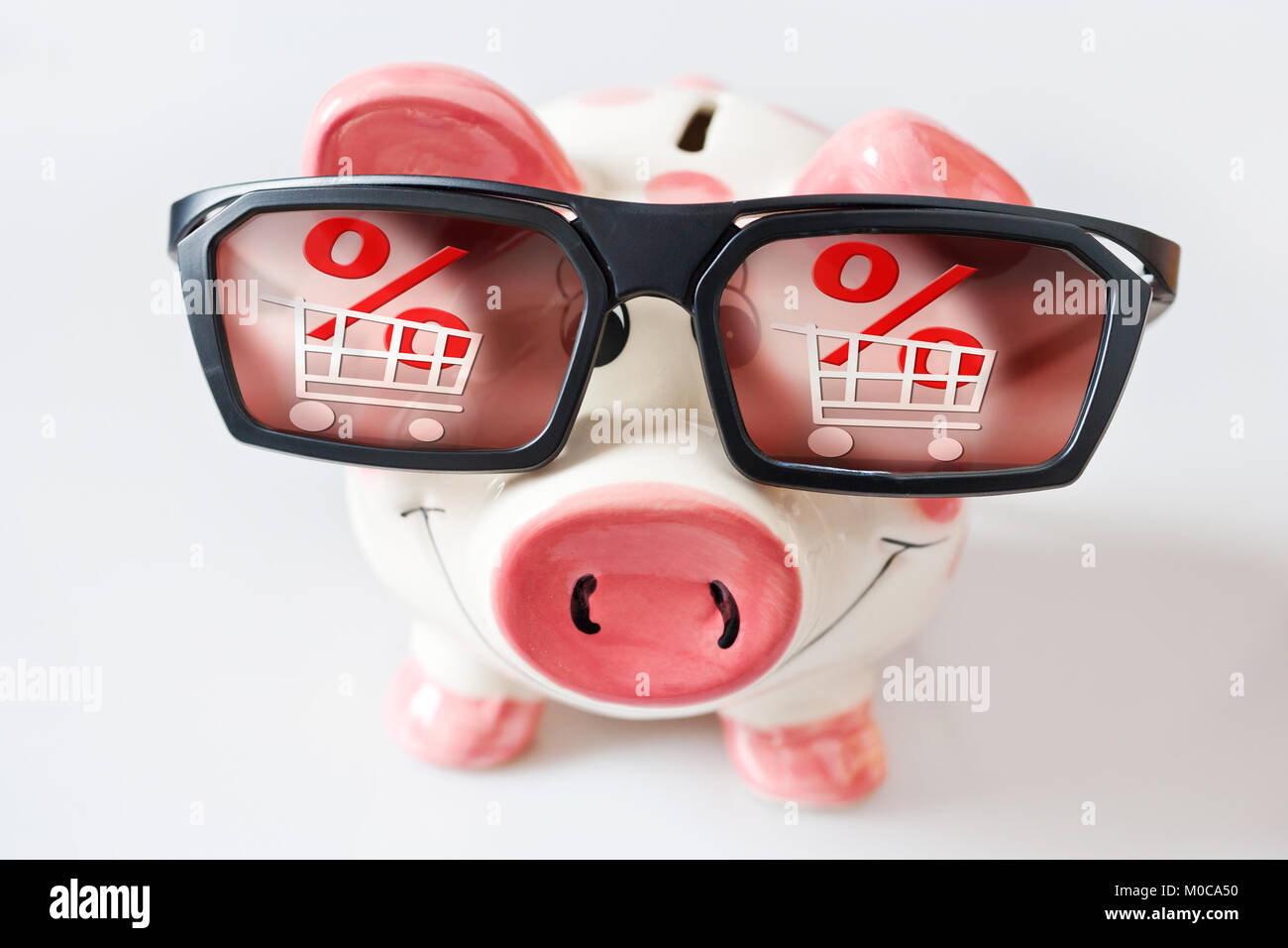 Wirtschaft und Finanzen - Sparschwein mit Brille und davon geträumt, niedrige Preise in Geschäften - Einsparungen für ein Einkaufszentrum im Vertrieb Stockfoto