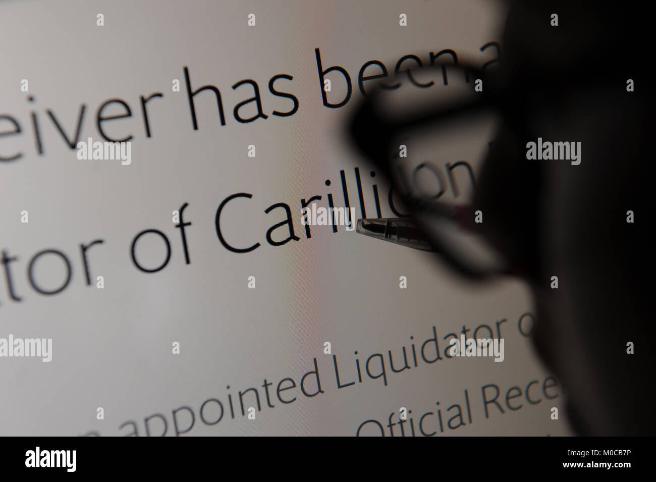 Eine Frau liest Details über die Verwalter der Carillion auf ihrer Website. Stockfoto