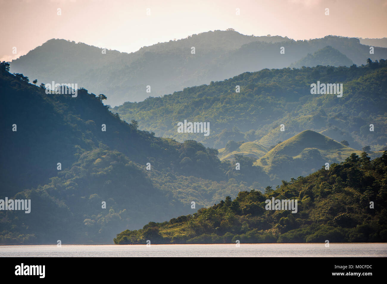 Dämmerung vor Sonnenaufgang auf dem Ozean Küste. Meer und Berge Landschaft am nebligen Morgen. Insel Komodo. Molukken, indonesischen Molukken, Spice Isla Stockfoto