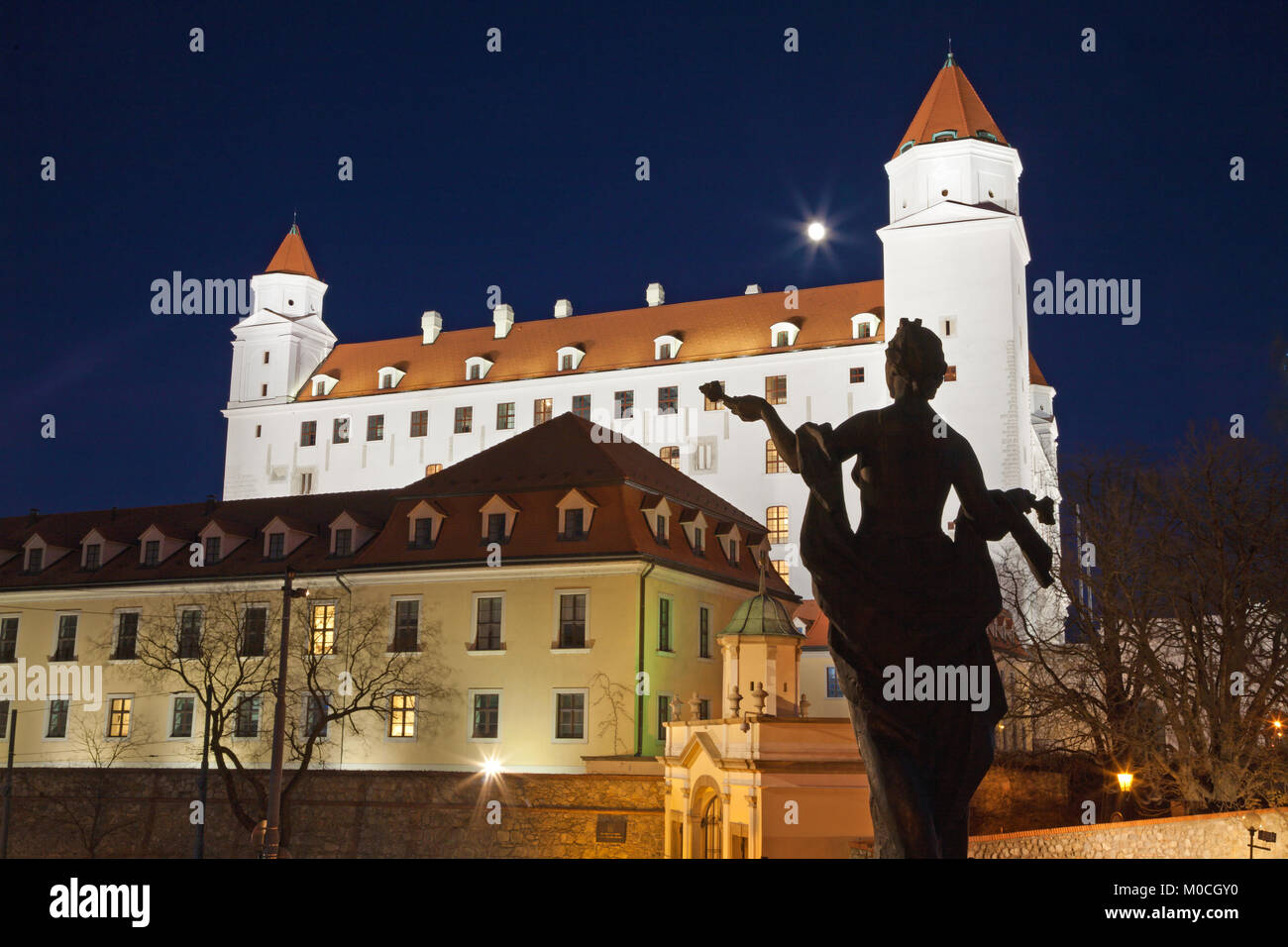 Bratislava - Das Schloss aus dem Parlament in der Nacht und die Silhouette der Statue. Stockfoto