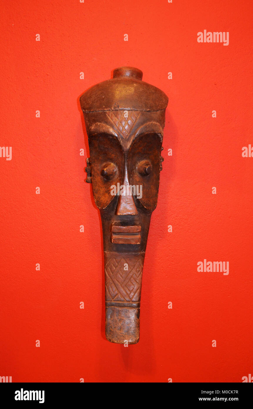 Afrikanische Maske auf einem roten Hintergrund isoliert. Stockfoto