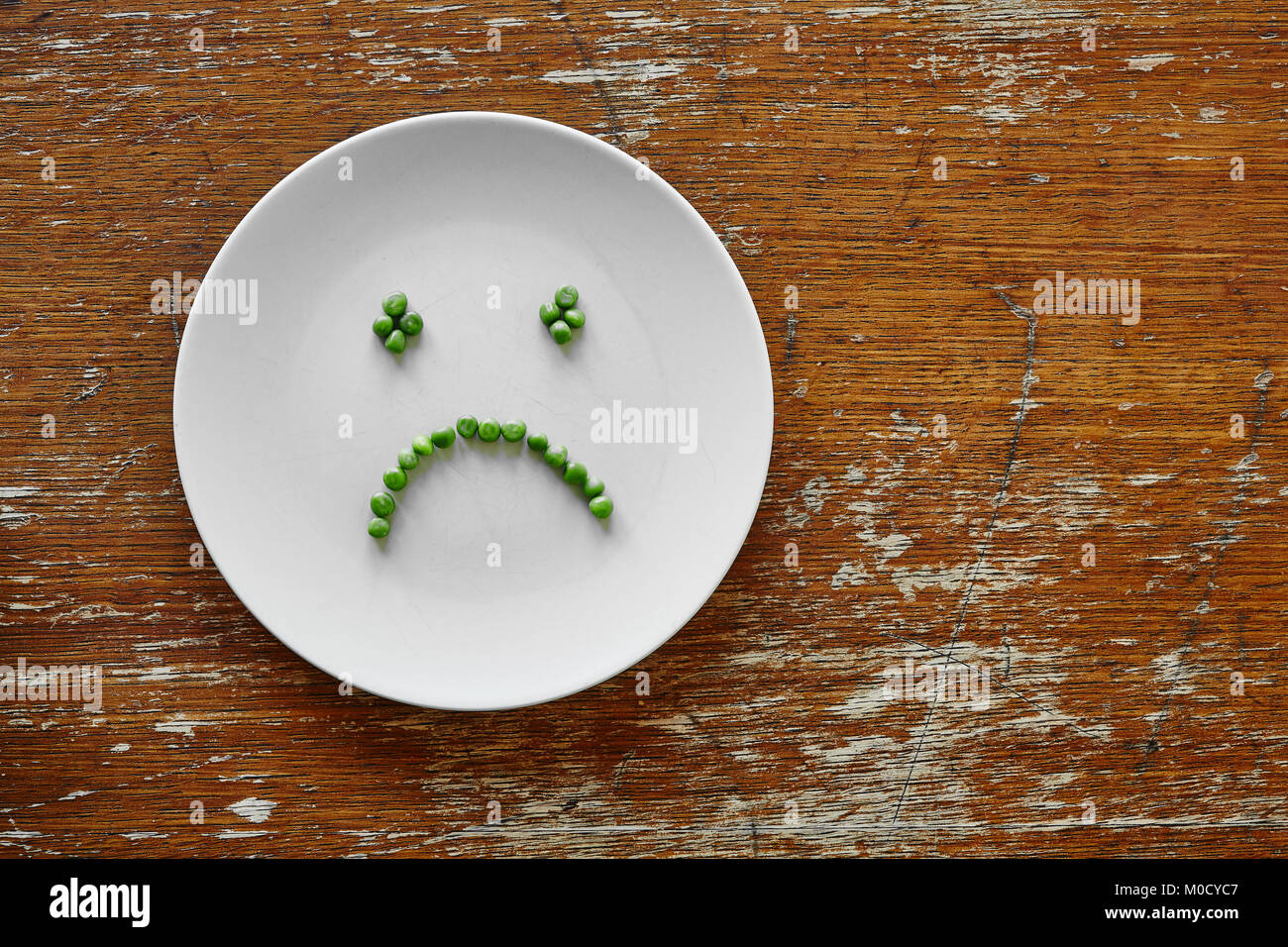 Traurig hunger Smiley aus Erbsen auf Platte Stockfoto