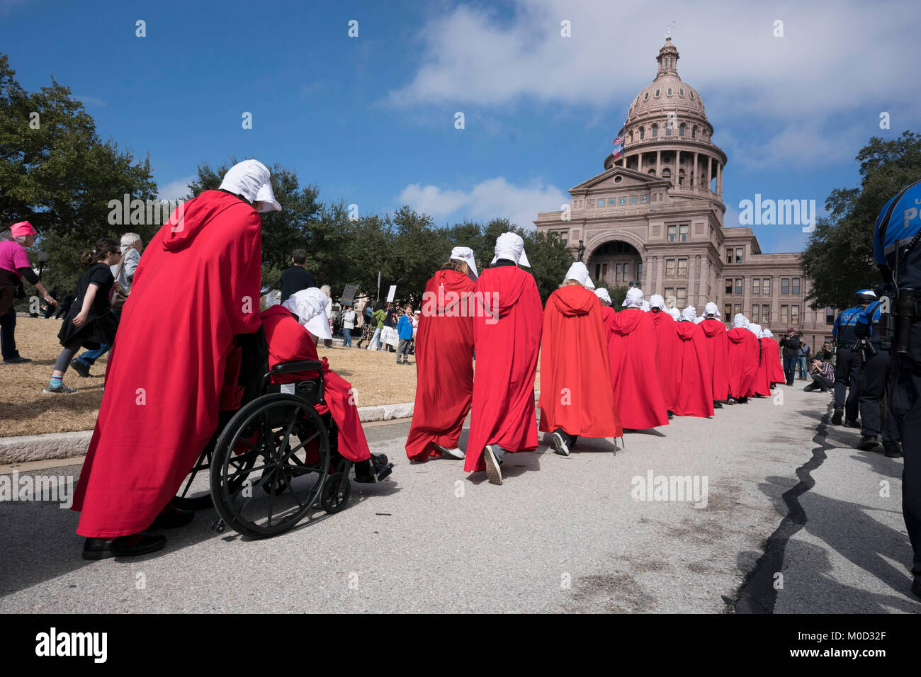 Frauen gekleidet als Zeichen von Buch Margaret Atwood's" ist eine Magd Erzählung "in einer Kundgebung an der Texas Capitol in Austin zum Gedenken an den ersten Jahrestag des März der Frauen auf Washington und politischen Maßnahmen, die sie im ersten Jahr Präsident Donald Trump im Amt erlassen gegen teilnehmen. Stockfoto