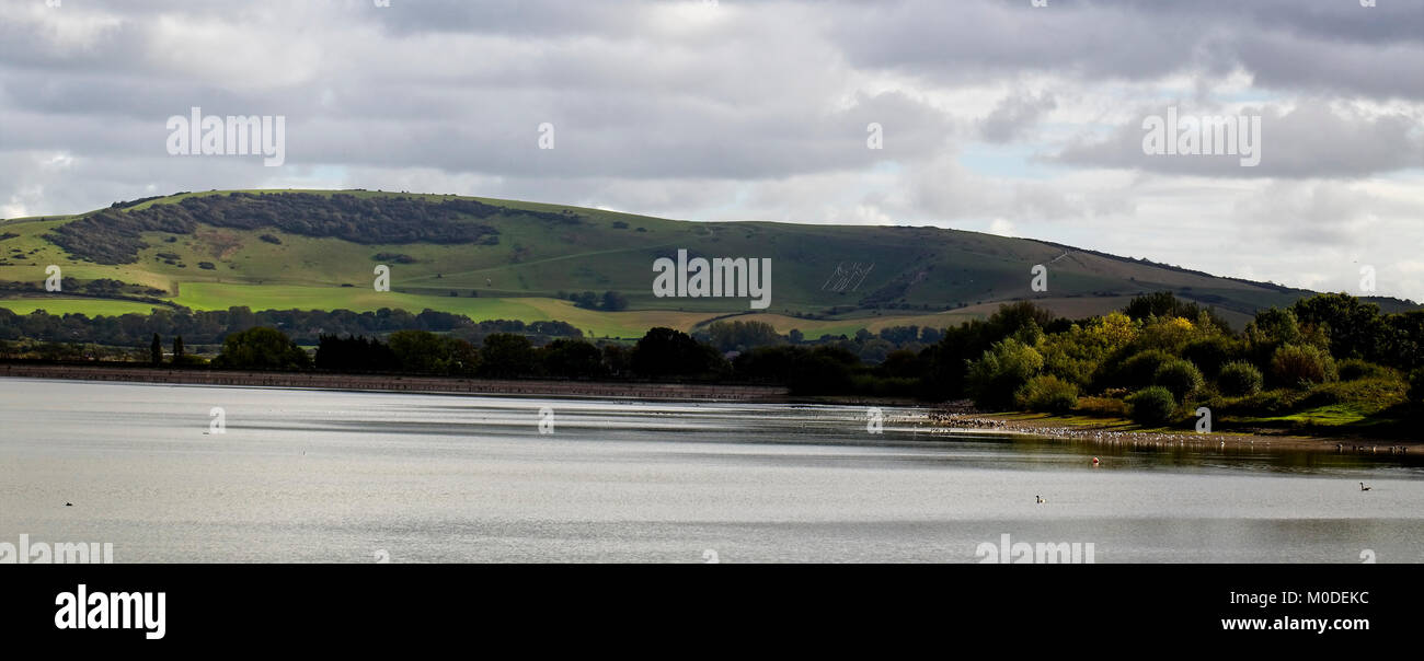 Der lange Mann von Wilmington in die South Downs über Arlington Reservoir, in der Nähe von Eastbourne, East Sussex, England, UK. Stockfoto