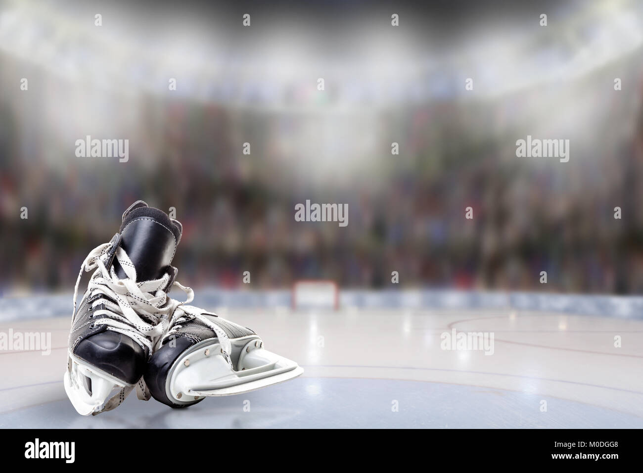 Low Angle View hockey Skates auf Eis mit absichtlichen flache Tiefenschärfe auf hell erleuchteten Stadion Hintergrund und Kopieren. Stockfoto