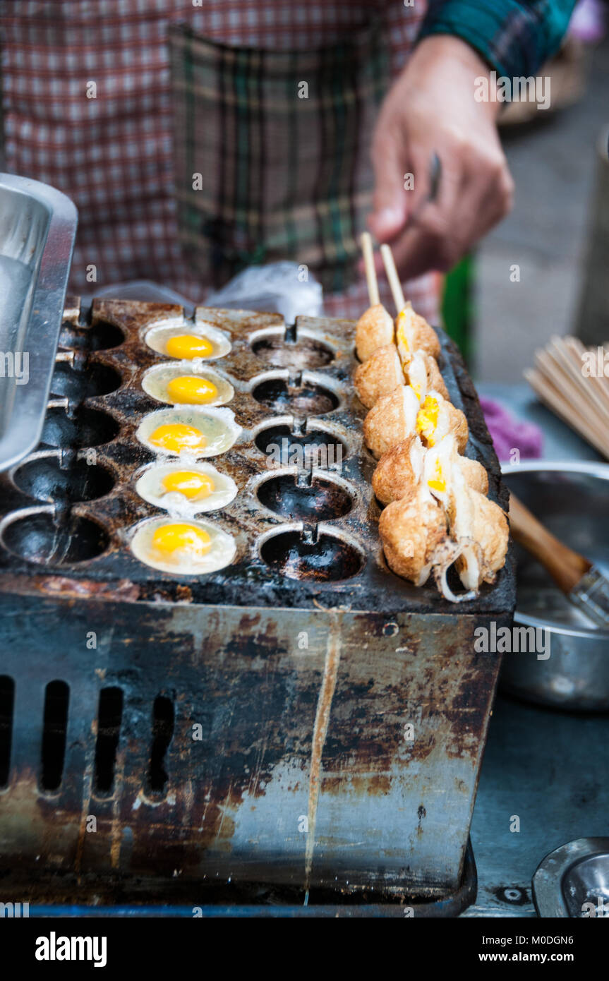 Frittieren Wachteleier auf einem Spieß als Street Food im muslimischen Viertel von Xi'an, China. In einer Reihe von drei. Stockfoto