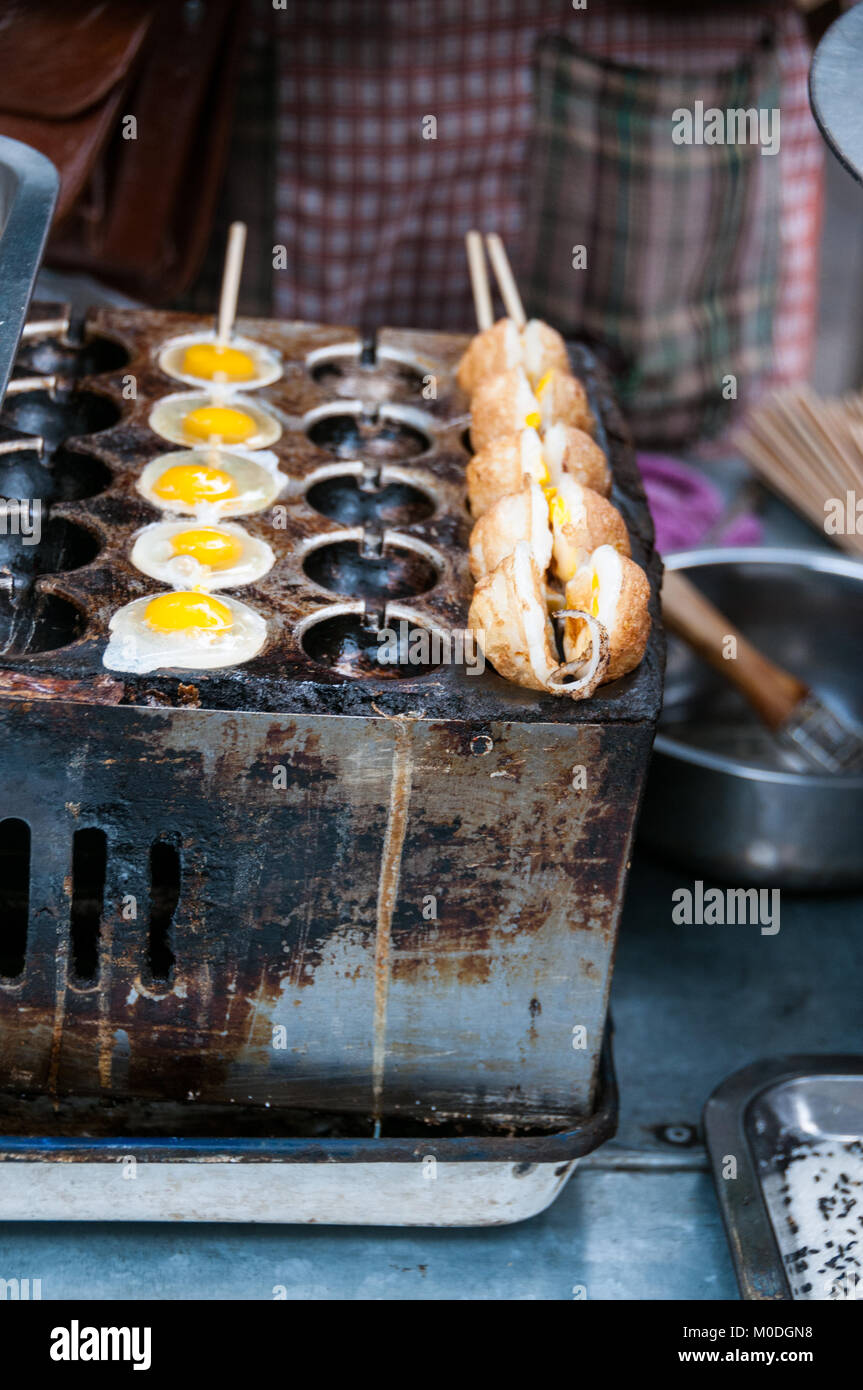 Frittieren Wachteleier auf einem Spieß als Street Food im muslimischen Viertel von Xi'an, China. In einer Reihe von drei. Stockfoto