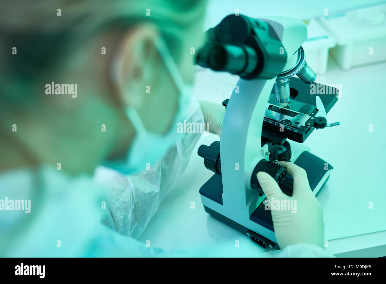 Frau mit Mikroskop im Labor Stockfoto