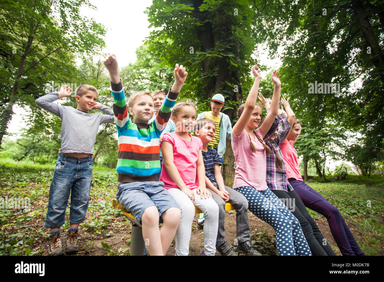 Gruppe von Kindern auf einer Parkbank Stockfoto