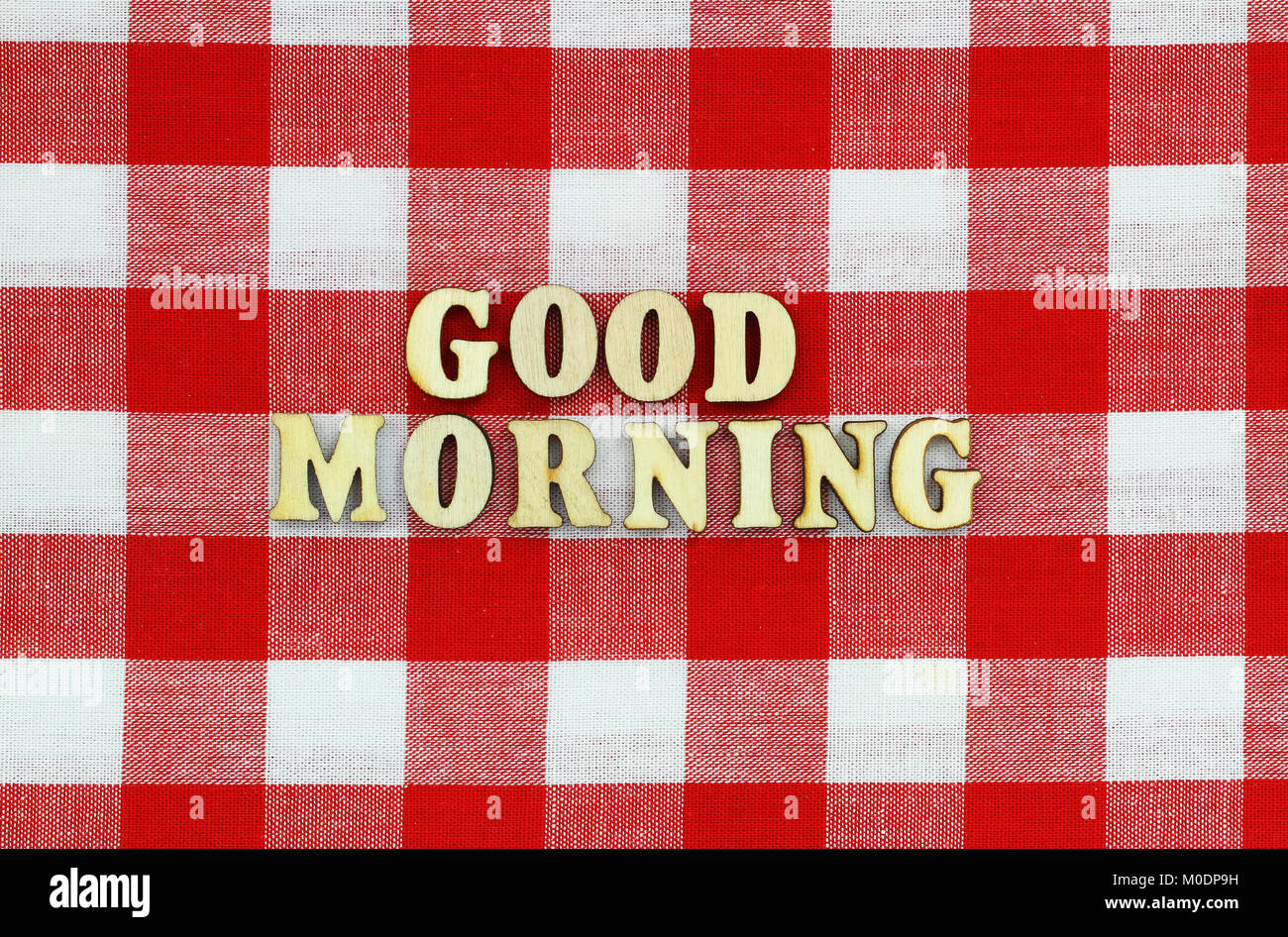 Guten Morgen mit Holz Buchstaben auf rot-weiß-karierten Tuch geschrieben Stockfoto