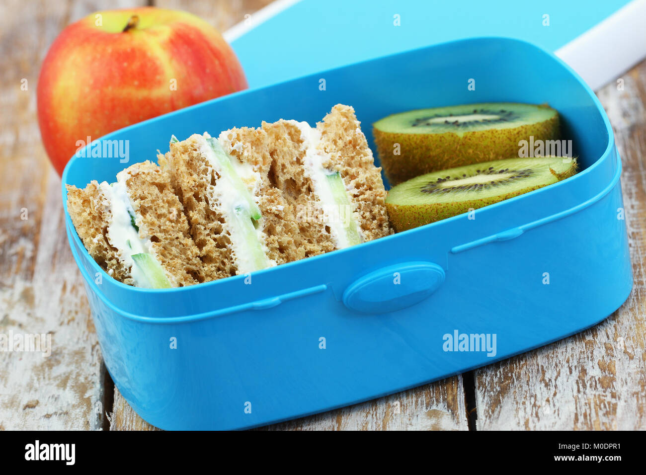 Gesunde Schule Lunch Box mit Brown Cream Cheese Sandwiches, Kiwi und Apple Stockfoto