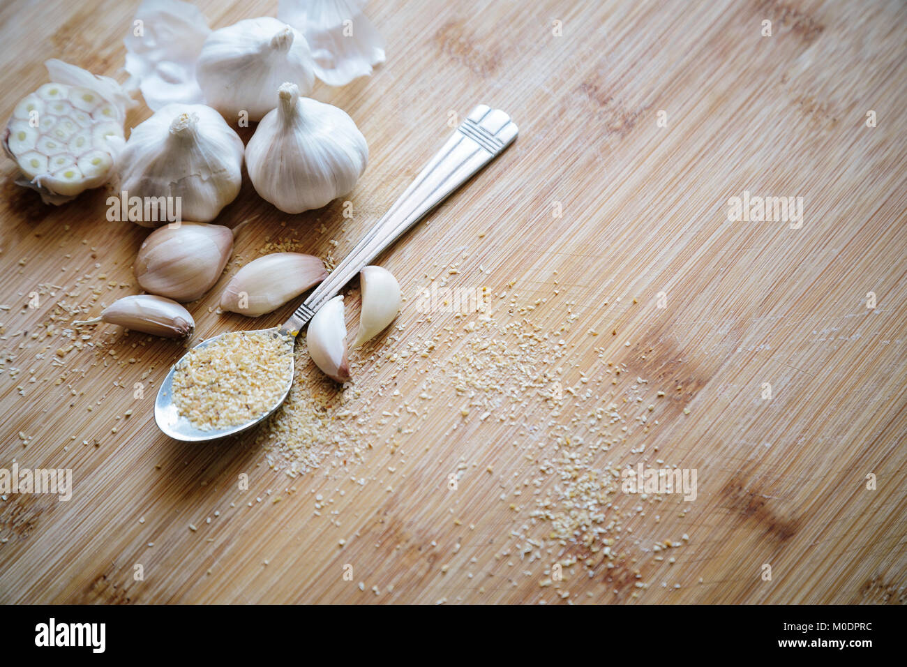 Knoblauch Zwiebeln, Knoblauchzehen und Knoblauch Pulver auf einem hölzernen Hintergrund Stockfoto