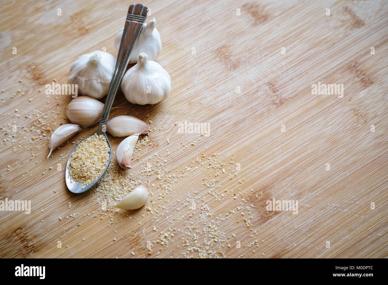 Knoblauch Zwiebeln, Knoblauchzehen und Knoblauch Pulver auf einem hölzernen Hintergrund Stockfoto