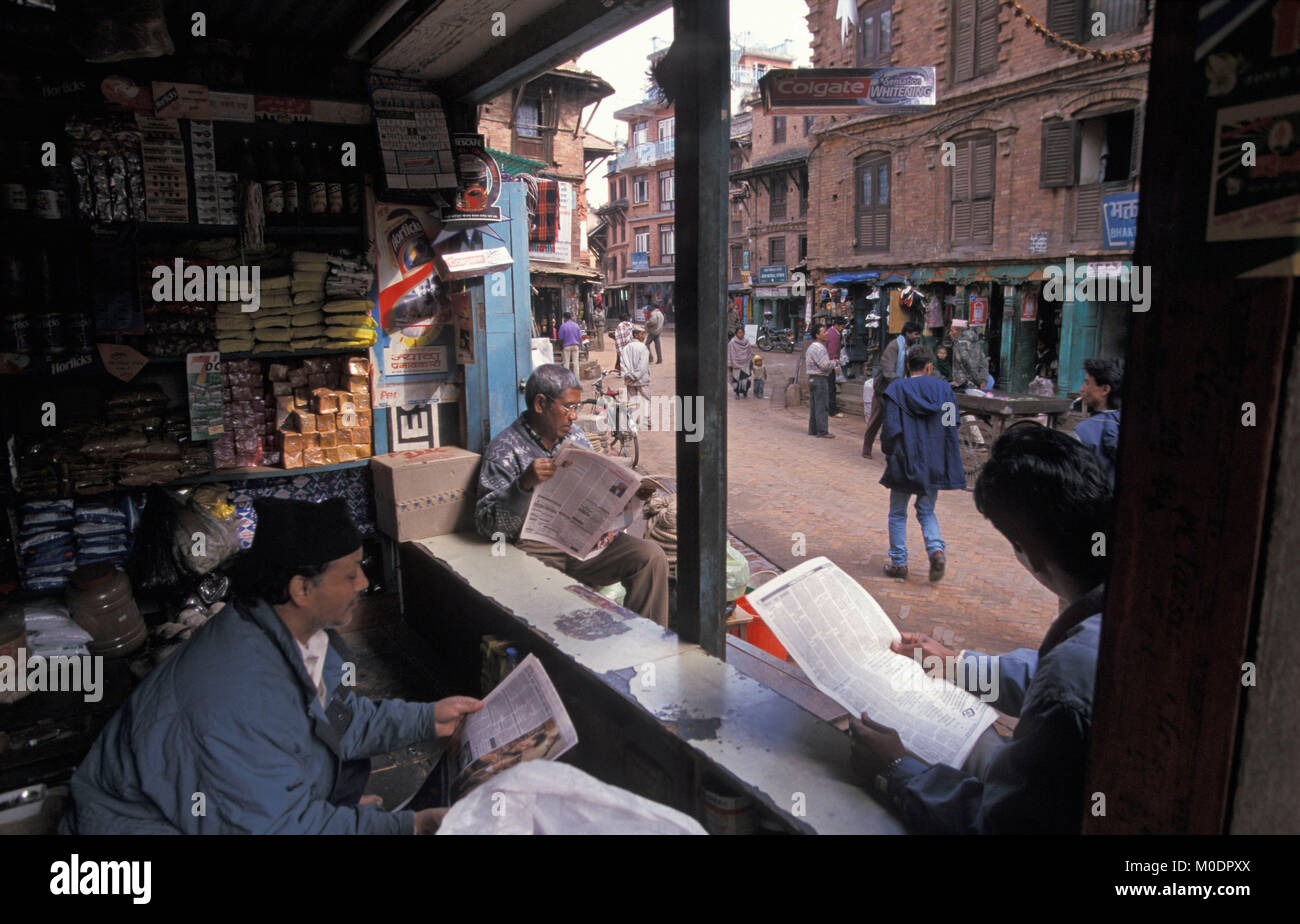 Nepal. Kathmandu, Bhaktapur. Männer lesen Zeitung im Shop. Stockfoto