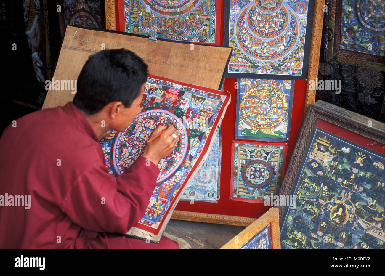Nepal. Kathmandu, Bhaktapur. Mann Malerei thanaka, religiöse Malerei, die das Leben des Buddha erzählt. Stockfoto