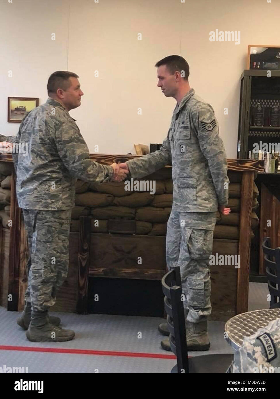 Maj. Michael Holt, seiner 627 Sicherheitskräfte Squadron Commander, präsentiert eine Münze zum Staff Sgt. Daniel Watkins, seiner 627 SFS Einheit Training Manager für herausragende ordnungsgemäße Flugzeugführung, Jan. 12, 2018 Joint Base Lewis-McChord, Washington Watkins ging über und über den Anruf der Aufgabe ein pensionierter Marine Corps Oberstleutnant zu unterstützen, ihn zu begleiten, um eine out-of-state Veterans Affairs Termin, und die dauerhafte Pflege des Gentleman. ( Stockfoto