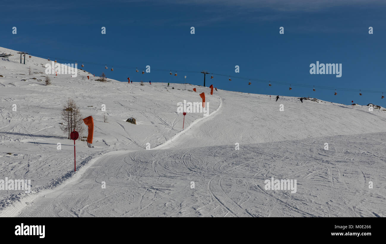 Alpe di Lusia, Italien. Dolomiten, Skigebiet mit schönen Pisten. Leere Skipiste im Winter an einem sonnigen Tag. Vorbereitung der Skipiste. Stockfoto