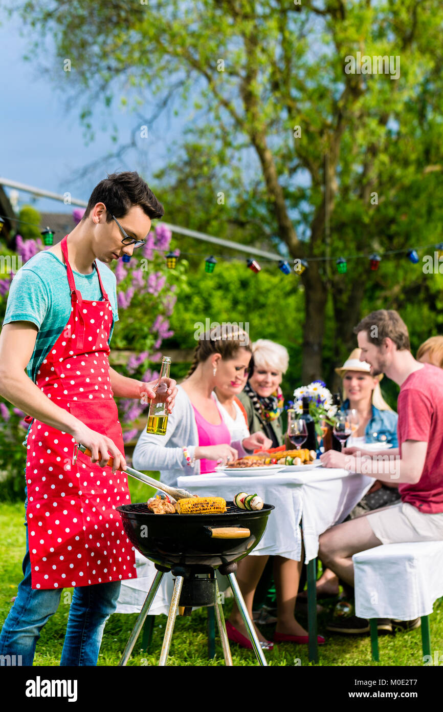 Man Grillen von Fleisch auf Garten Grill Party Stockfoto