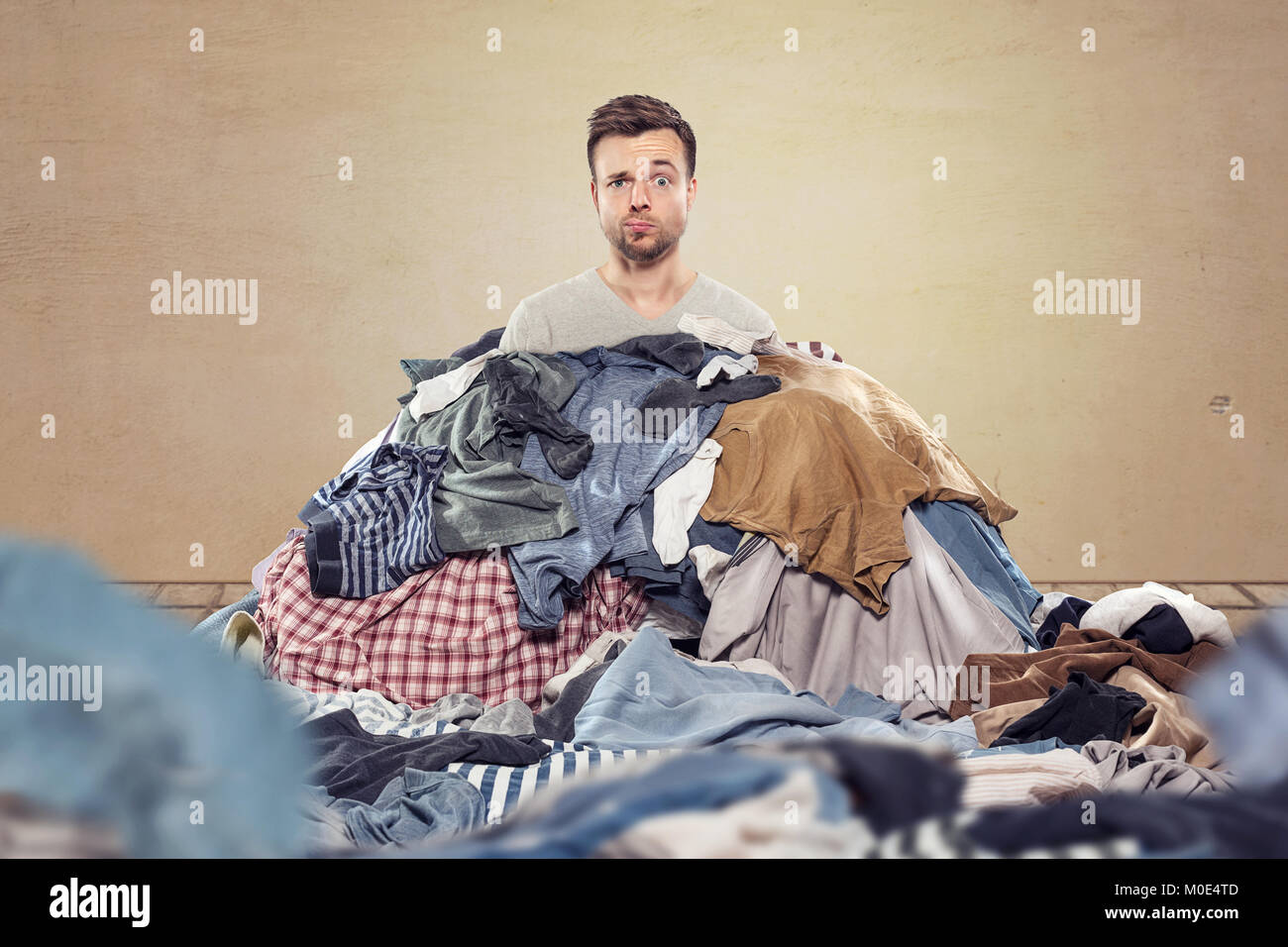 Mann in einem Durcheinander von Wäscheservice Stockfoto