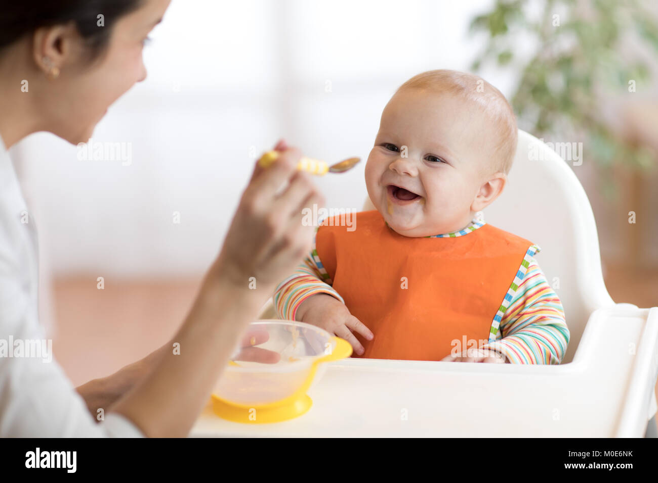 Junge Mutter ihr Baby Sohn Fütterung mit Fruchtpüree Stockfoto