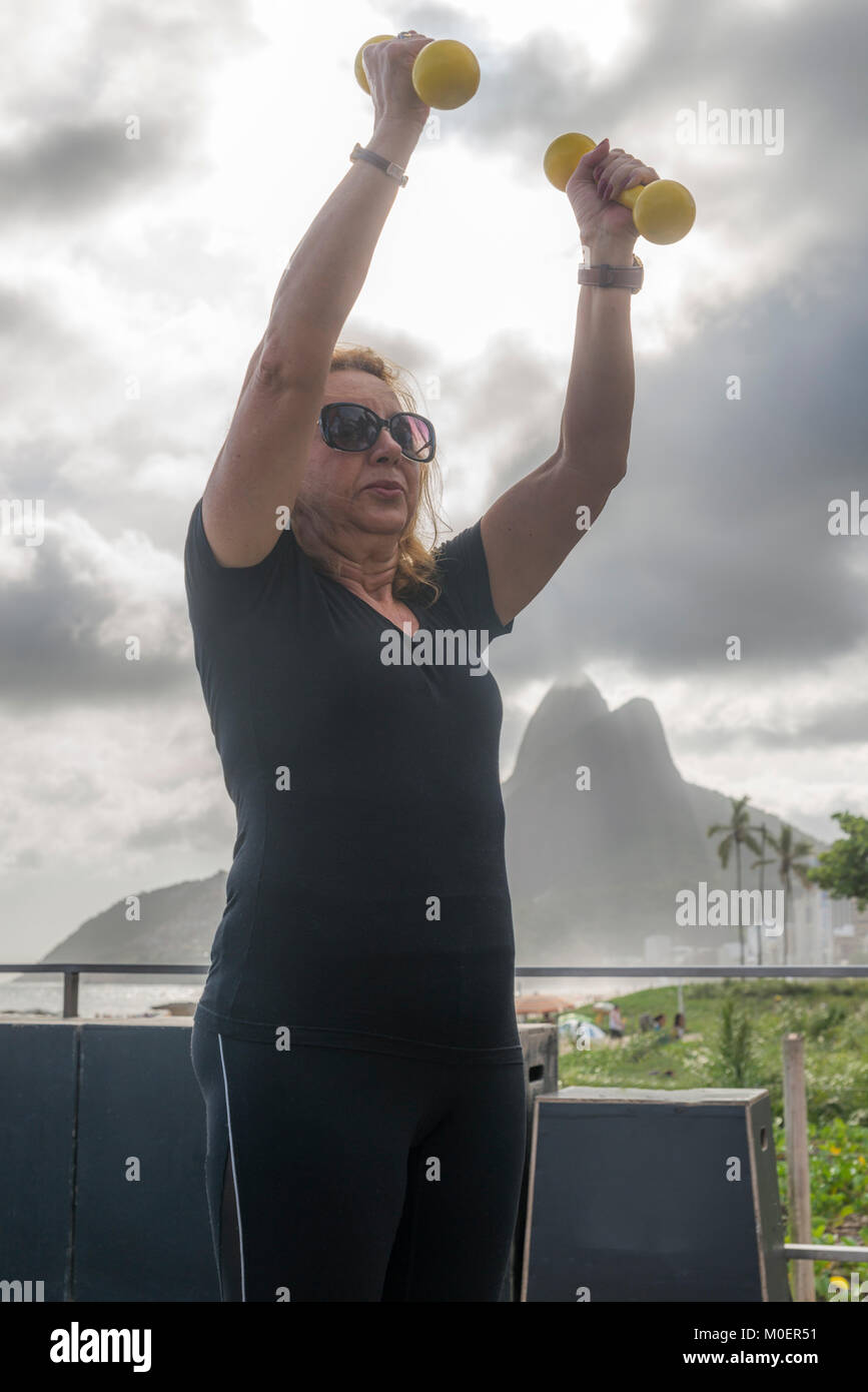 Model Released: reife Frau (70-79) Training mit Kurzhanteln an öffentlichen Turnhalle in Ipanema, Rio de Janeiro, Brasilien Stockfoto