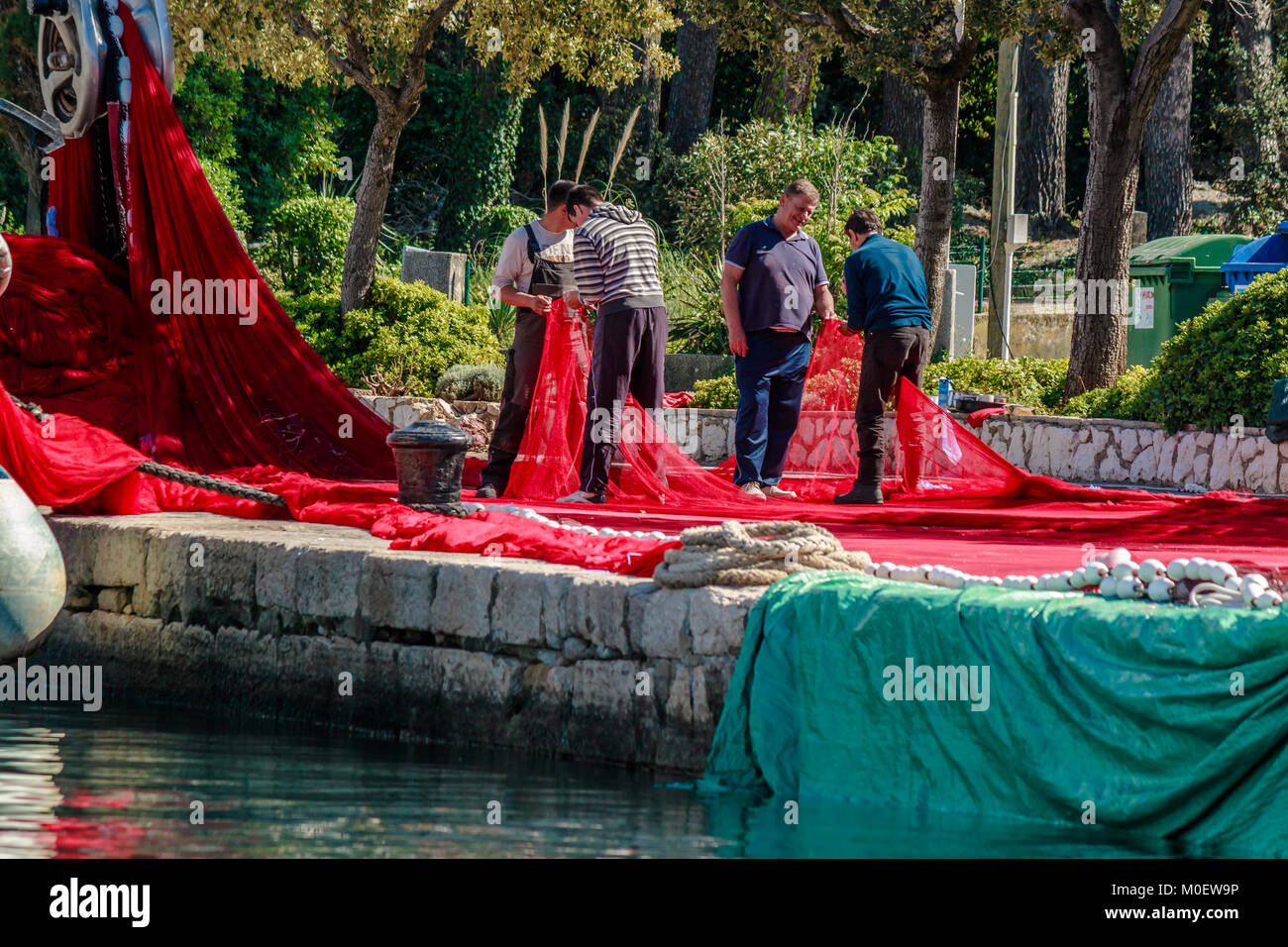 Fischer Flicken der Netze auf Kai, Krk, Kroatien. Mai 2017. Stockfoto