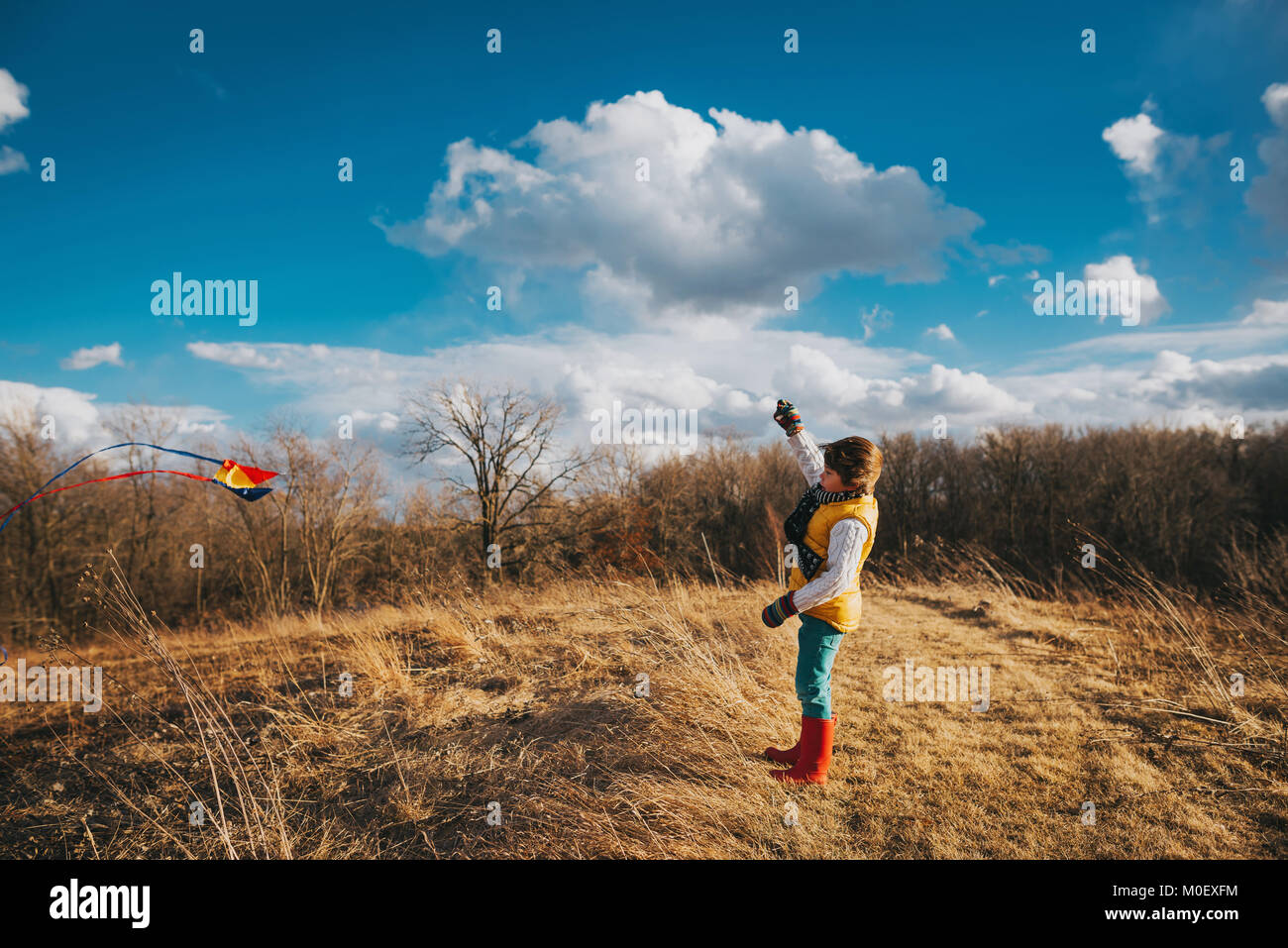 Junge in einer ländlichen Landschaft flying a Kite Stockfoto