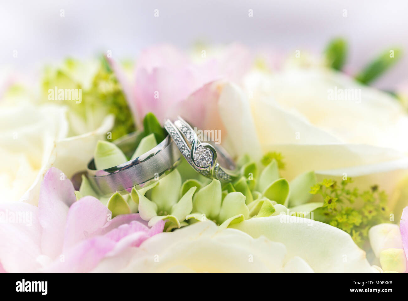 Hochzeit Ringe auf einem Blumenstrauß Stockfoto