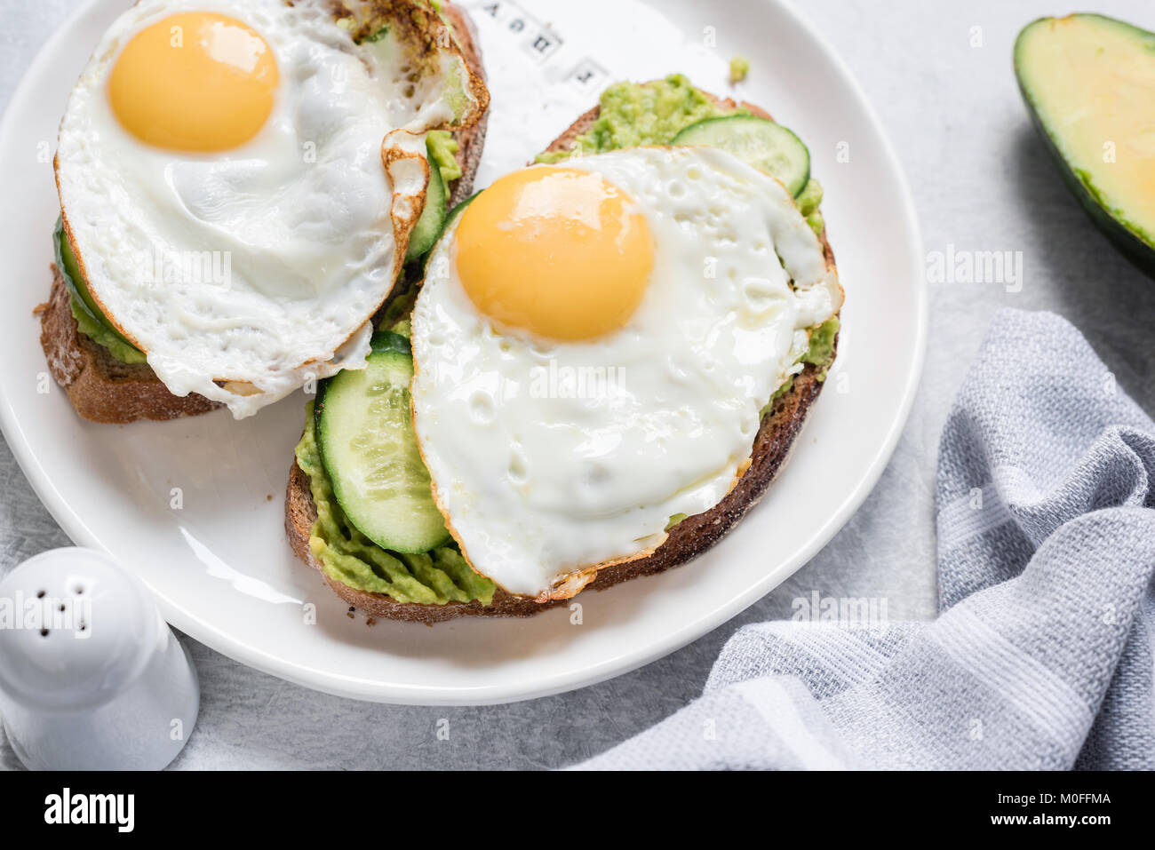 Ei und Avocado Frühstück Toast auf weiße Platte. Detailansicht. Gesunde Ernährung Diät Konzept Stockfoto