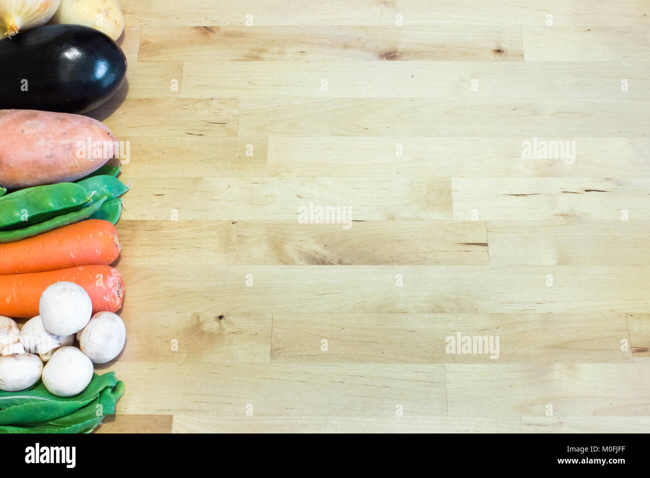 Gemüse aufgereiht auf Holz- Hintergrund mit leeren Raum für Text, Gestaltung oder Einrichtung. Gesunde vegetarische, vegane Ernährung, der Begriff. Stockfoto