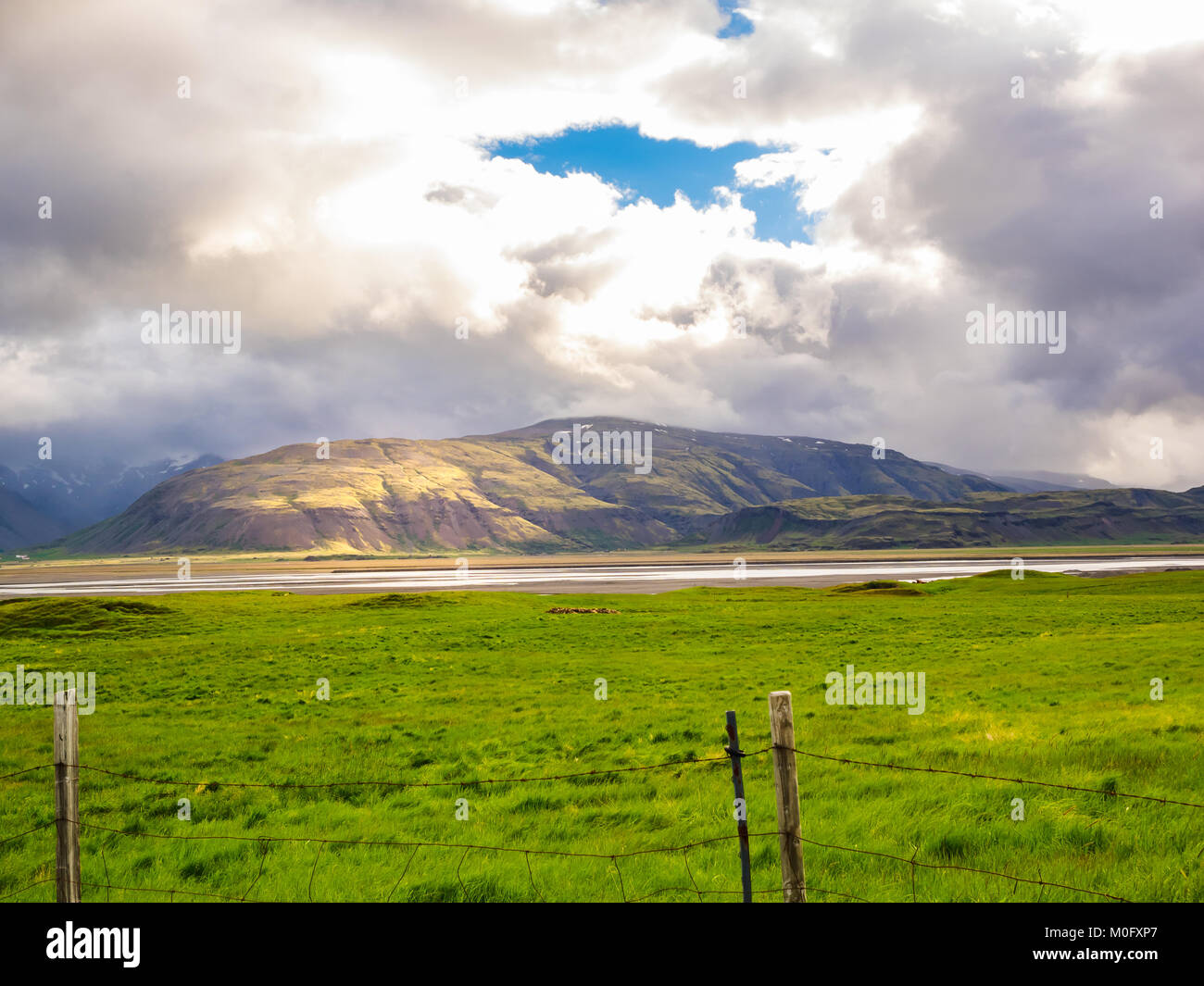 Dramatische island Landschaft mit Berg- und grünes Feld im Sommer Stockfoto