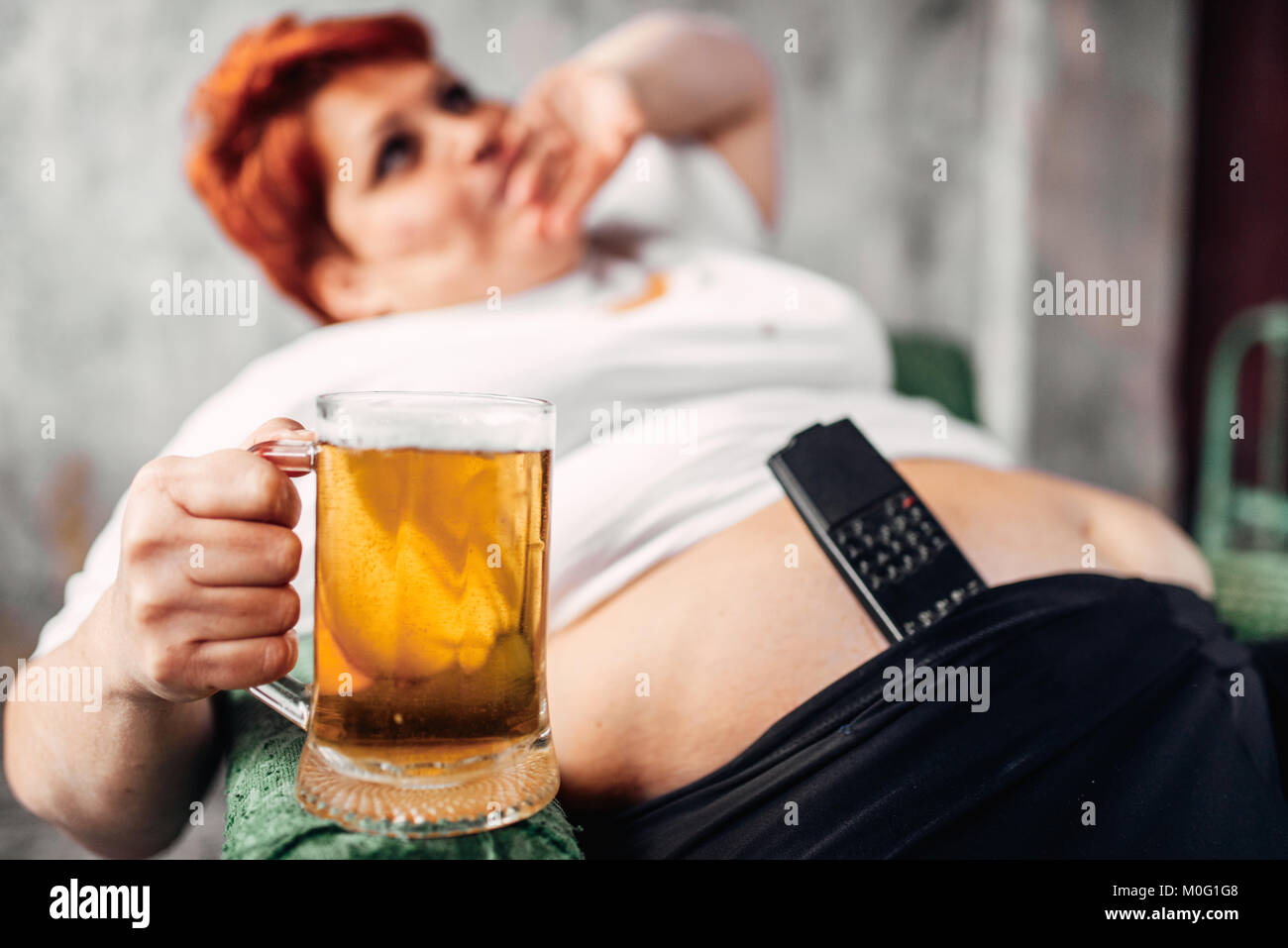 Übergewichtige Frau mit einem Glas Bier in der Hand, Fettleibigkeit. Ungesunde Lebensweise, Fettsäuren Weiblich Stockfoto