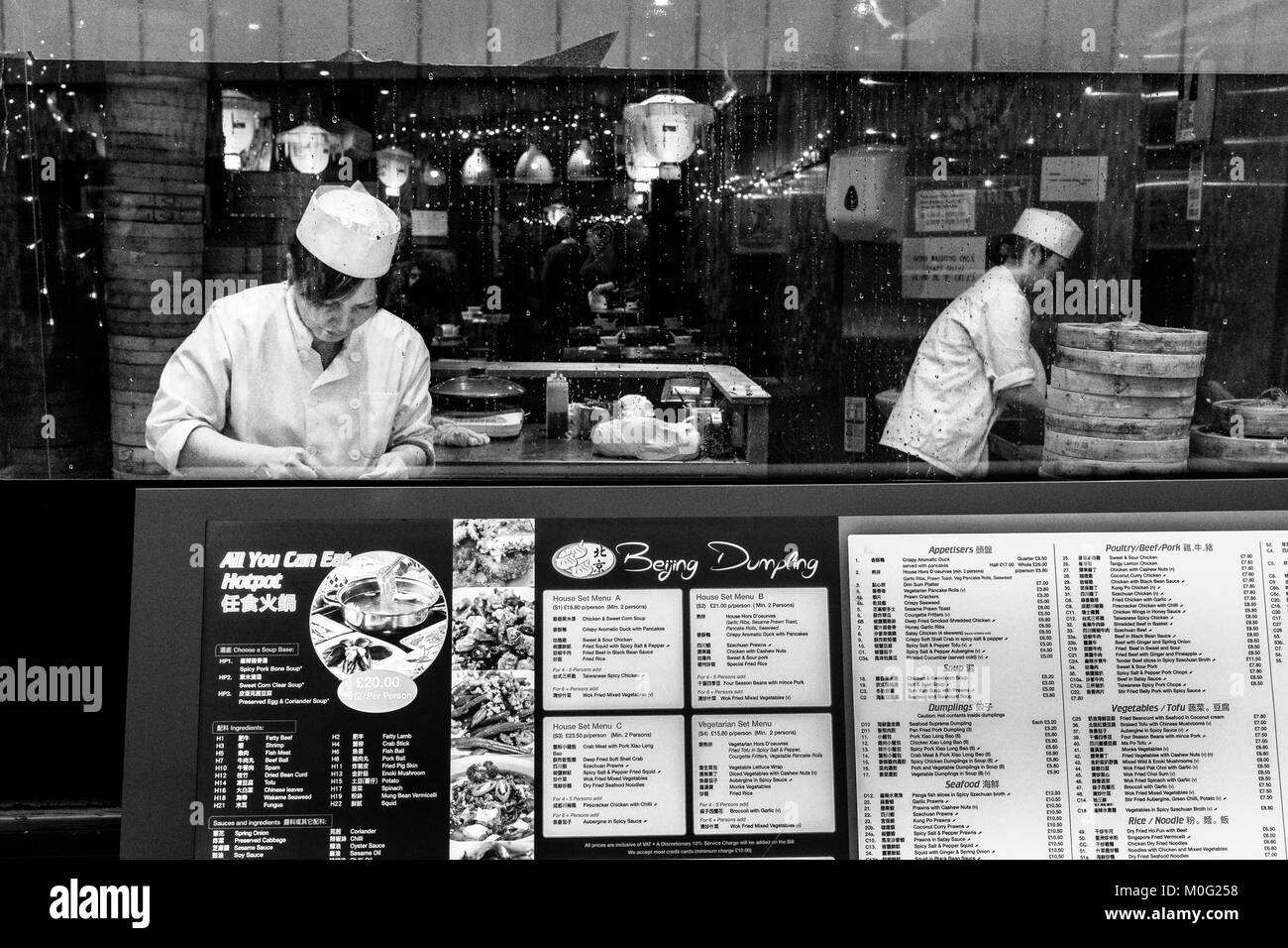 Schwarz-Weiß-Straßenfotografie in London: Restaurantpersonal bereitet Knödel in Chinatown, London, zu. Stockfoto