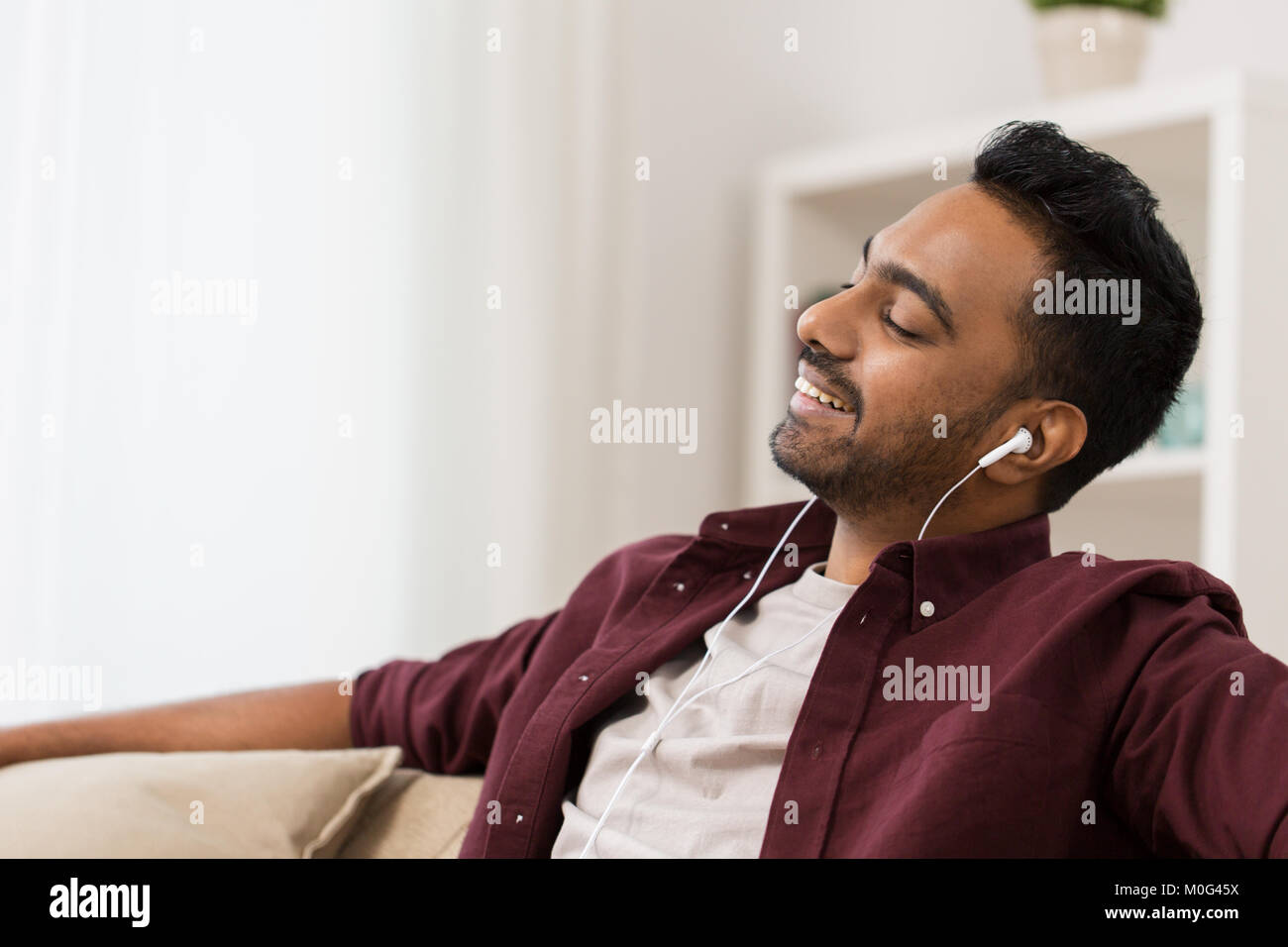 Glückliche Menschen im Kopfhörer zu Hause Musik hören Stockfoto
